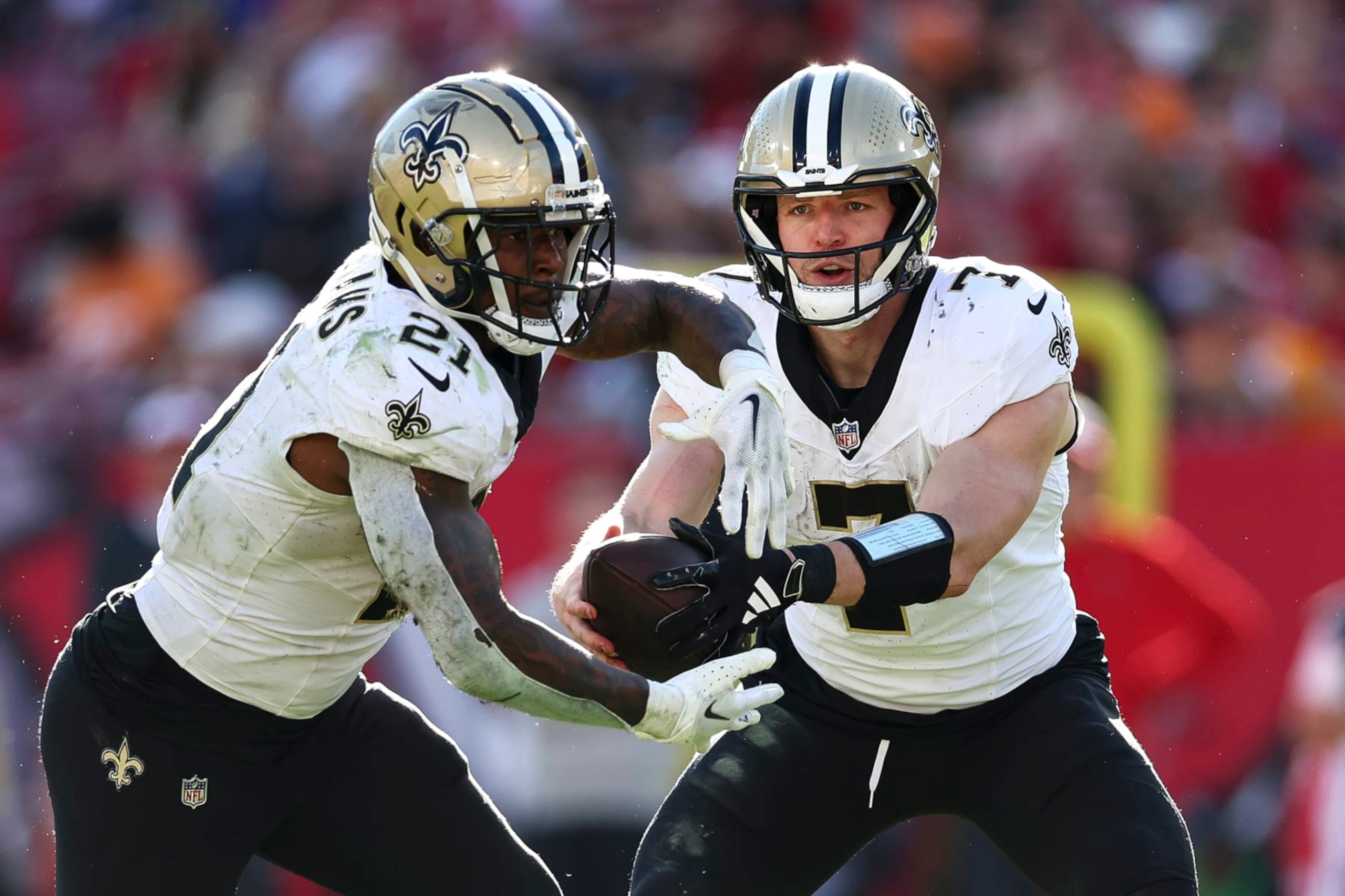 TAMPA, FL - DECEMBER 31: Taysom Hill #7 of the New Orleans Saints hands the ball off to Jamaal Williams #21 during the fourth quarter of an NFL football game at Raymond James Stadium on December 31, 2023 in Tampa, Florida. (Photo by Kevin Sabitus/Getty Images)