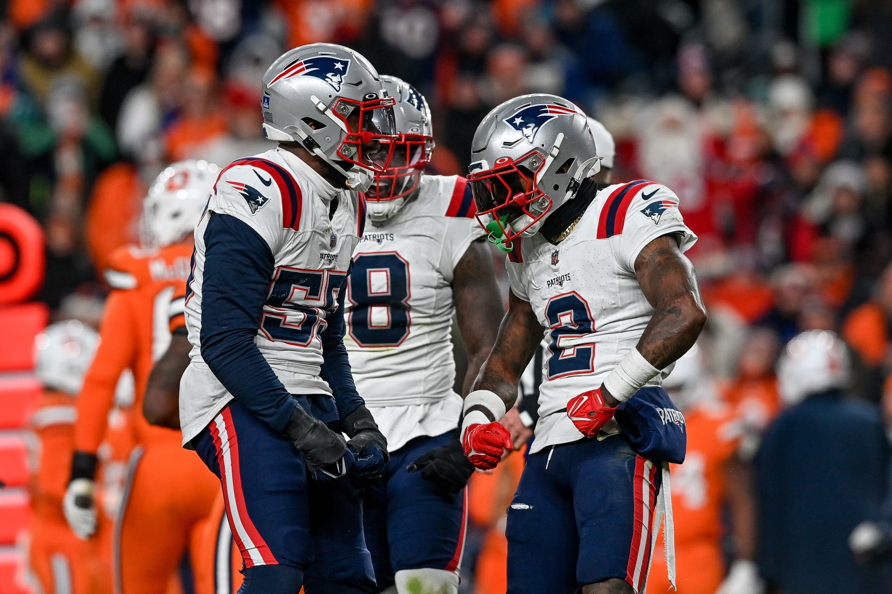 DENVER, COLORADO - DECEMBER 24:  Josh Uche #55, Ja'Whaun Bentley #8, and Jalen Mills #2 of the New England Patriots celebrate after a defensive play against the Denver Broncos in the second half of a game at Empower Field at Mile High on December 24, 2023 in Denver, Colorado. (Photo by Dustin Bradford/Getty Images)