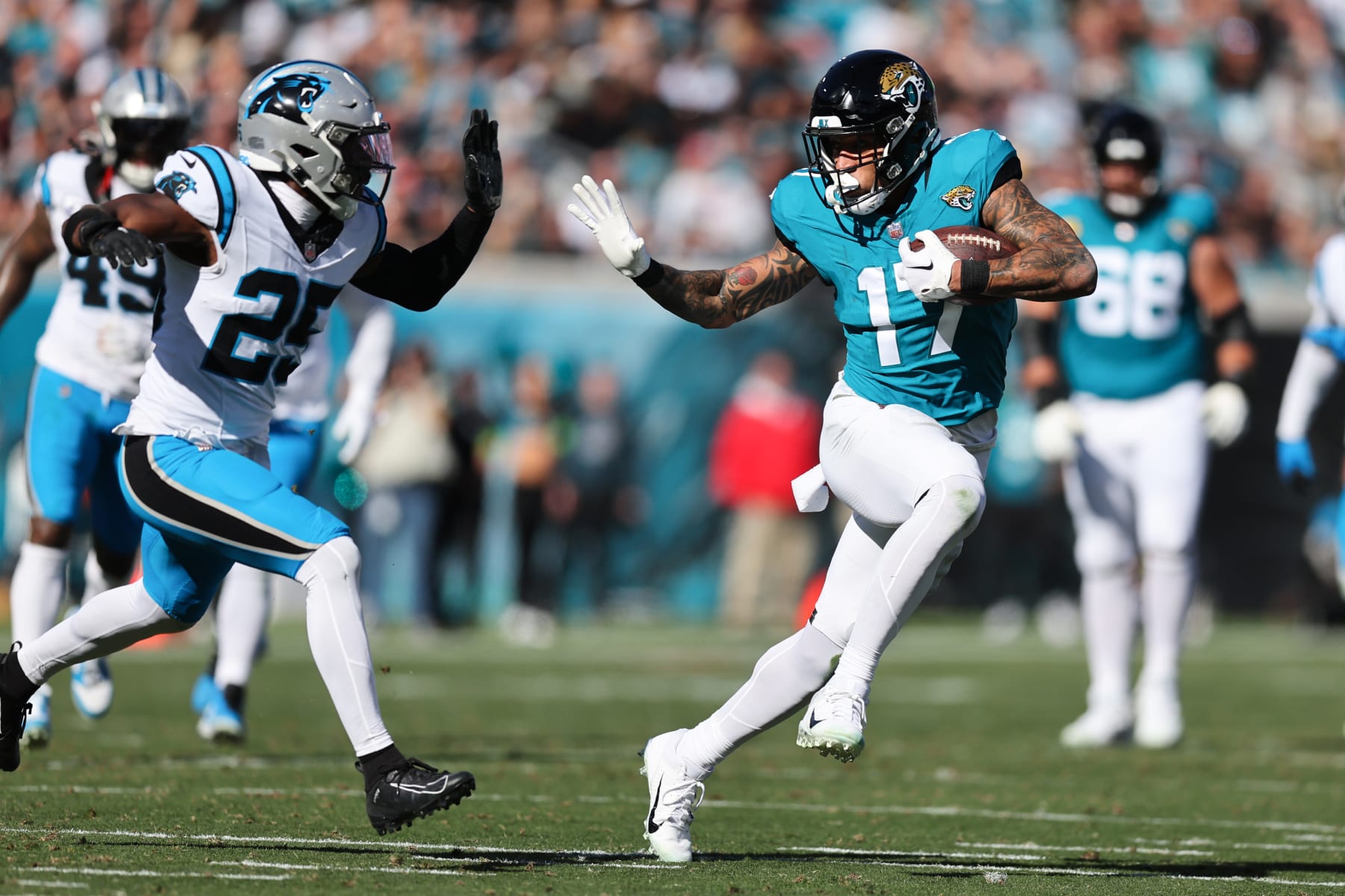 JACKSONVILLE, FLORIDA - DECEMBER 31: Evan Engram #17 of the Jacksonville Jaguars runs past Xavier Woods #25 of the Carolina Panthers during the first half at EverBank Stadium on December 31, 2023 in Jacksonville, Florida. (Photo by Mike Carlson/Getty Images)