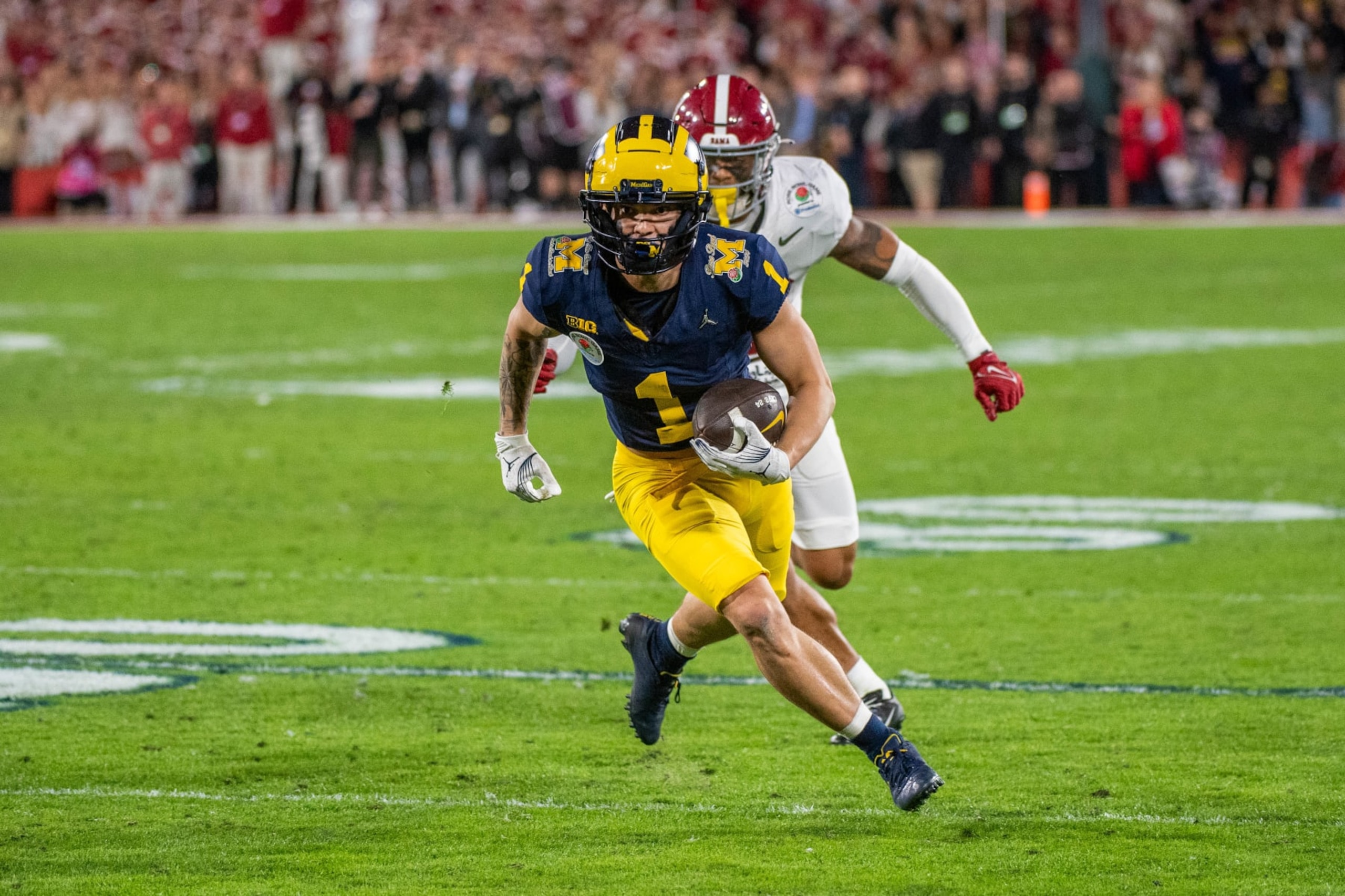 PASADENA, CALIFORNIA - JANUARY 01: Roman Wilson #1 of the Michigan runs with the ball for yardage away from Malachi Moore #13 of the Alabama Crimson Tide during the second half of the CFP Semifinal Rose Bowl Game at Rose Bowl Stadium on January 01, 2024 in Pasadena, California. The Michigan Wolverines won the game 27-20 in overtime. (Photo by Aaron J. Thornton/Getty Images) PASADENA, CALIFORNIA - JANUARY 01: Roman Wilson #1 of the Michigan runs with the ball for yardage away from Malachi Moore #13 of the Alabama Crimson Tide during the second half of the CFP Semifinal Rose Bowl Game at Rose Bowl Stadium on January 01, 2024 in Pasadena, California. The Michigan Wolverines won the game 27-20 in overtime. (Photo by Aaron J. Thornton/Getty Images)