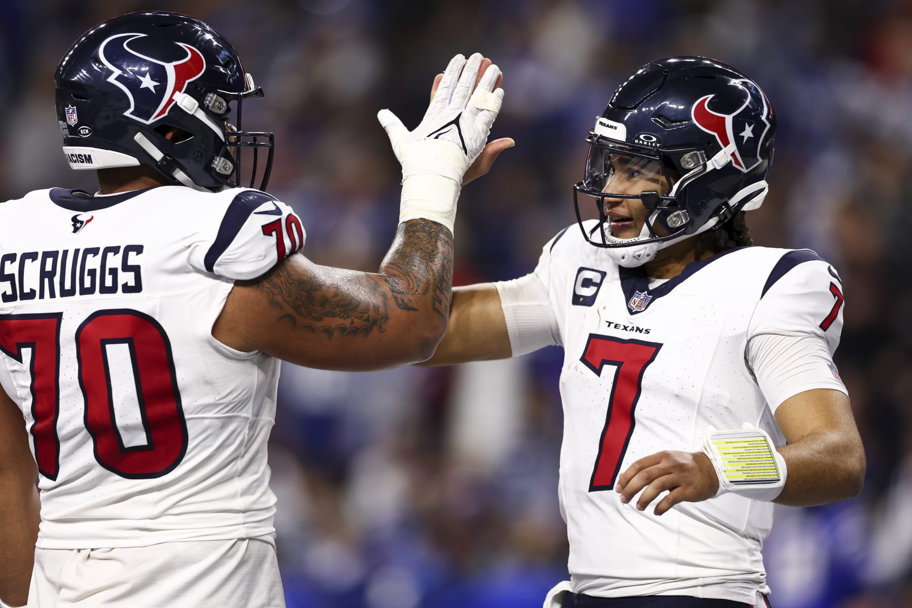 INDIANAPOLIS, IN - JANUARY 6: C.J. Stroud #7 of the Houston Texans high fives Juice Scruggs #70 after throwing a touchdown pass during the second quarter of an NFL football game against the Indianapolis Colts at Lucas Oil Stadium on January 6, 2024 in Indianapolis, Indiana. (Photo by Kevin Sabitus/Getty Images)