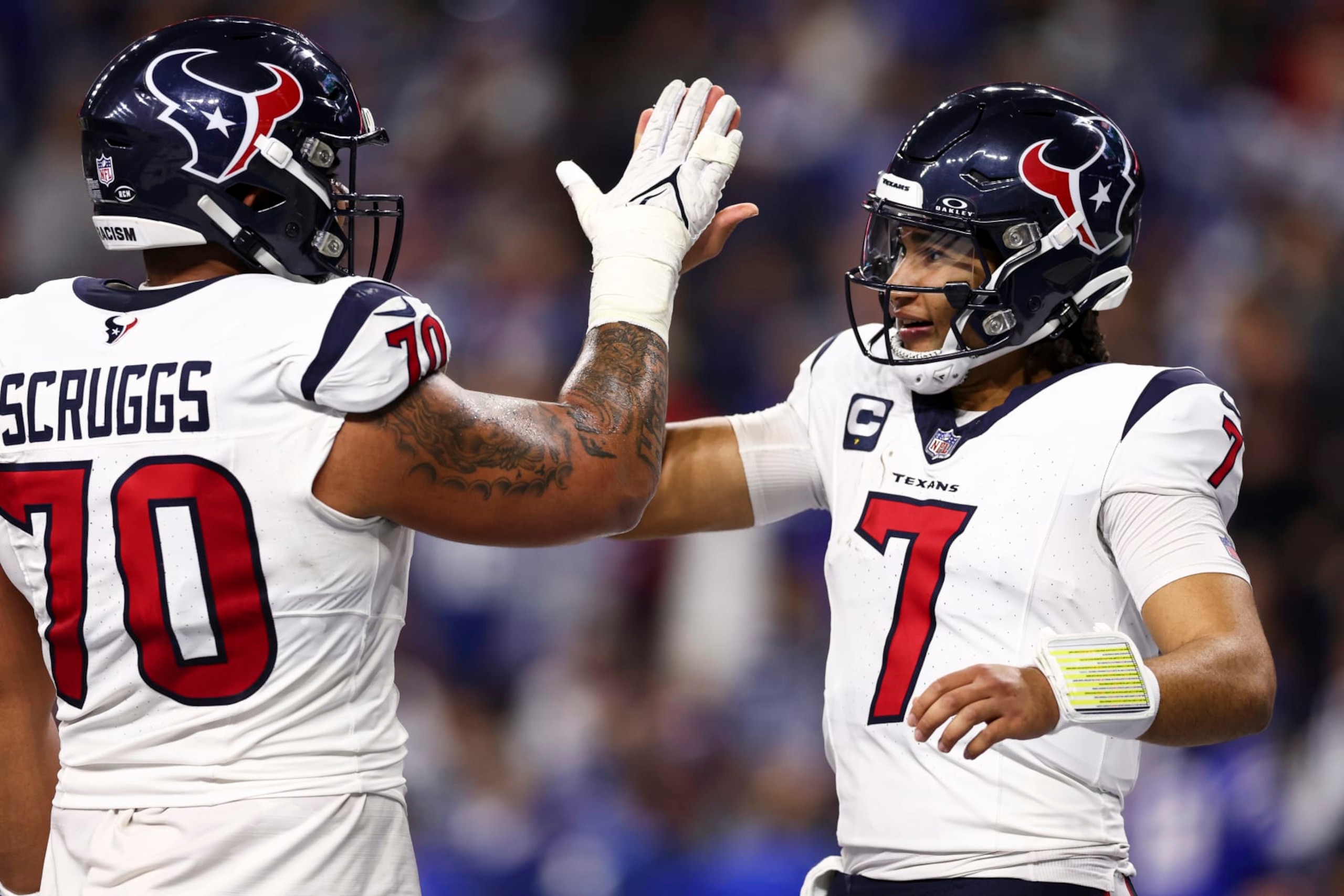 INDIANAPOLIS, IN - JANUARY 6: C.J. Stroud #7 of the Houston Texans high fives Juice Scruggs #70 after throwing a touchdown pass during the second quarter of an NFL football game against the Indianapolis Colts at Lucas Oil Stadium on January 6, 2024 in Indianapolis, Indiana. (Photo by Kevin Sabitus/Getty Images)