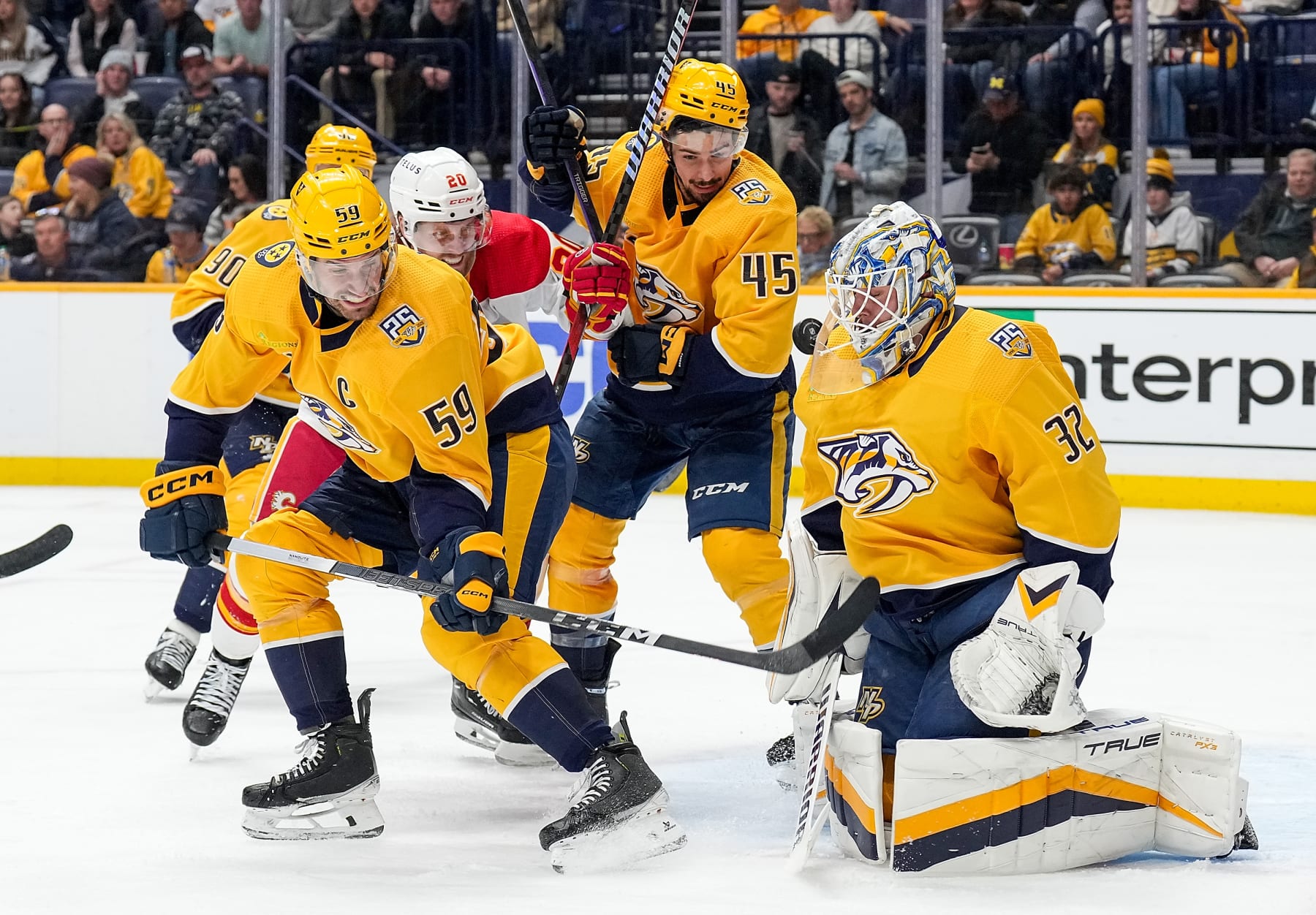 NASHVILLE, TENNESSEE - JANUARY 4: Kevin Lankinen #32 of the Nashville Predators makes a save as Blake Coleman #20 of the Calgary Flames battles in front of the net against Roman Josi #59 and Alexandre Carrier #45 during an NHL game at Bridgestone Arena on January 4, 2024 in Nashville, Tennessee. (Photo by John Russell/NHLI via Getty Images)