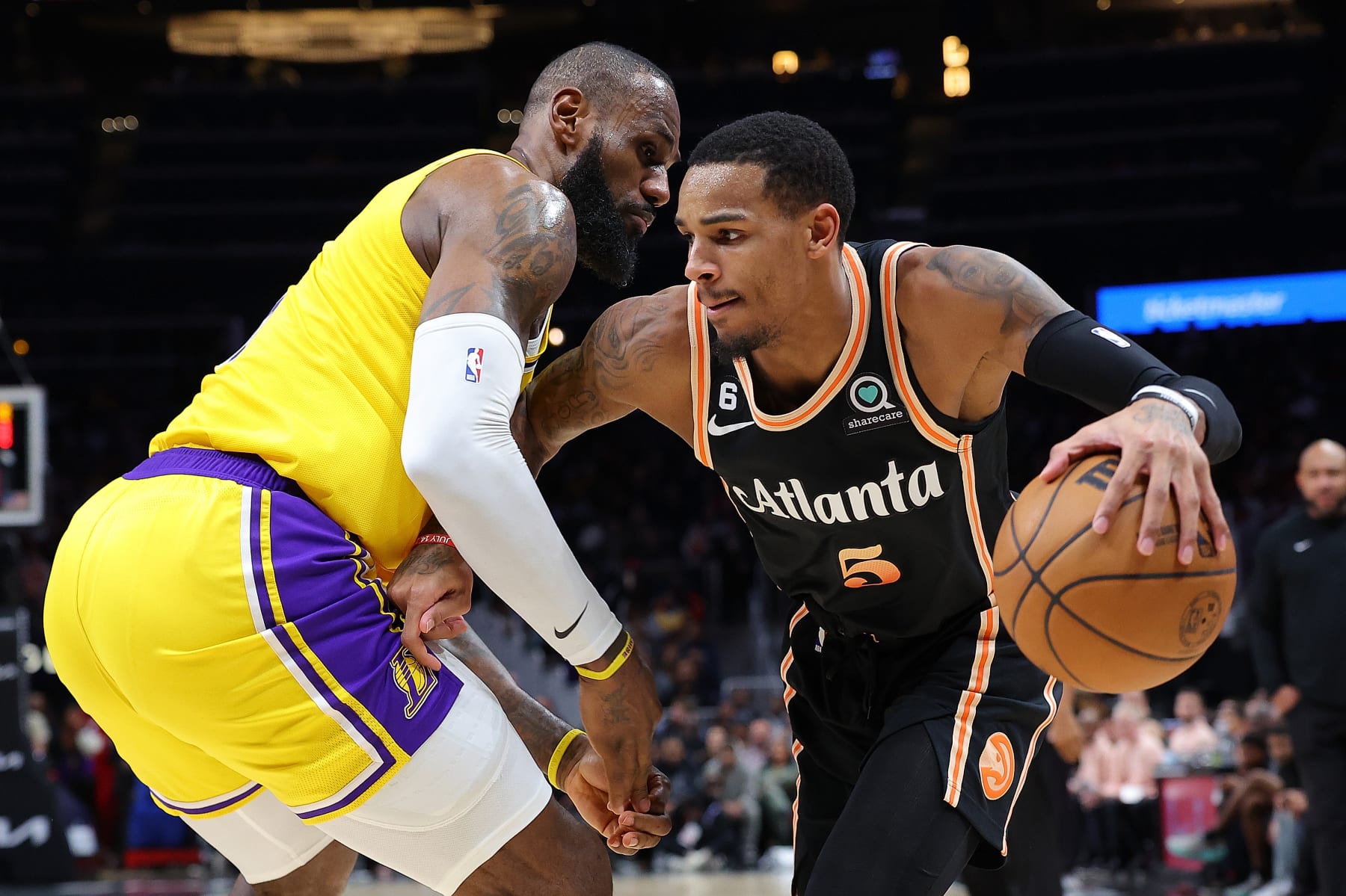 ATLANTA, GEORGIA - DECEMBER 30:  Dejounte Murray #5 of the Atlanta Hawks drives against LeBron James #6 of the Los Angeles Lakers during the second quarter at State Farm Arena on December 30, 2022 in Atlanta, Georgia.  NOTE TO USER: User expressly acknowledges and agrees that, by downloading and or using this photograph, User is consenting to the terms and conditions of the Getty Images License Agreement.  (Photo by Kevin C. Cox/Getty Images)