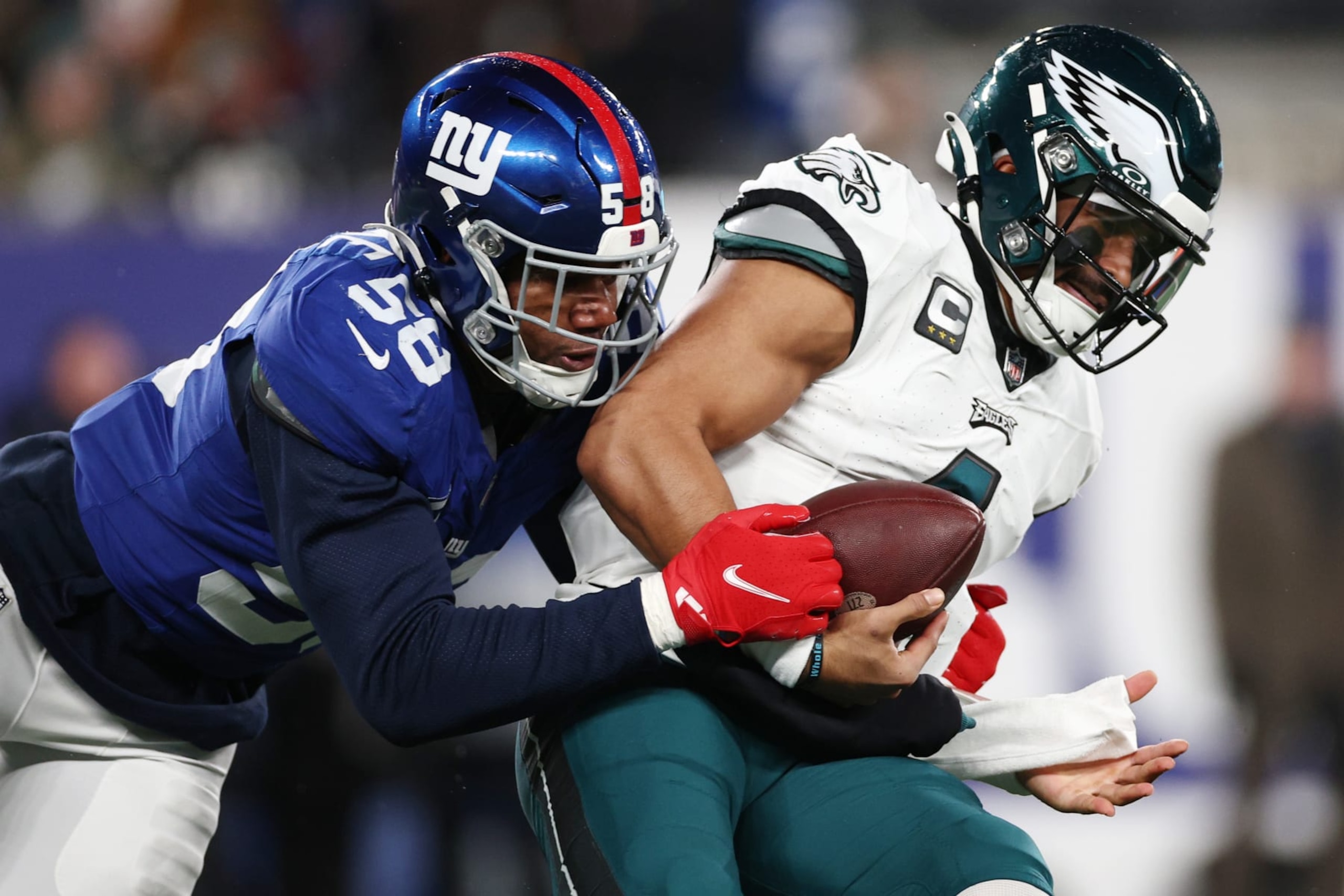 Eagles QB Jalen Hurts is tackled by Giants LB Bobby Okereke
