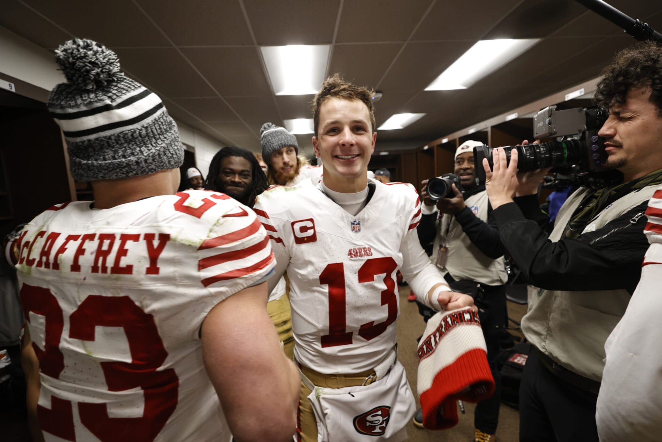 LANDOVER, MD - DECEMBER 31: Christian McCaffrey #23 and Brock Purdy #13 of the San Francisco 49ers celebrate in the locker room after the game against the Washington Commanders at FedEx Field on December 31, 2023 in Landover, Maryland. The 49ers defeated the Commanders 27-10. (Photo by Michael Zagaris/San Francisco 49ers/Getty Images)