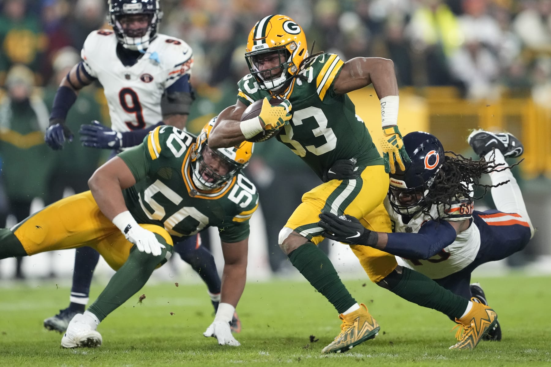 GREEN BAY, WISCONSIN - JANUARY 07: Aaron Jones #33 of the Green Bay Packers is tackled by Tremaine Edmunds #49 of the Chicago Bears during the third quarter at Lambeau Field on January 07, 2024 in Green Bay, Wisconsin. (Photo by Patrick McDermott/Getty Images)