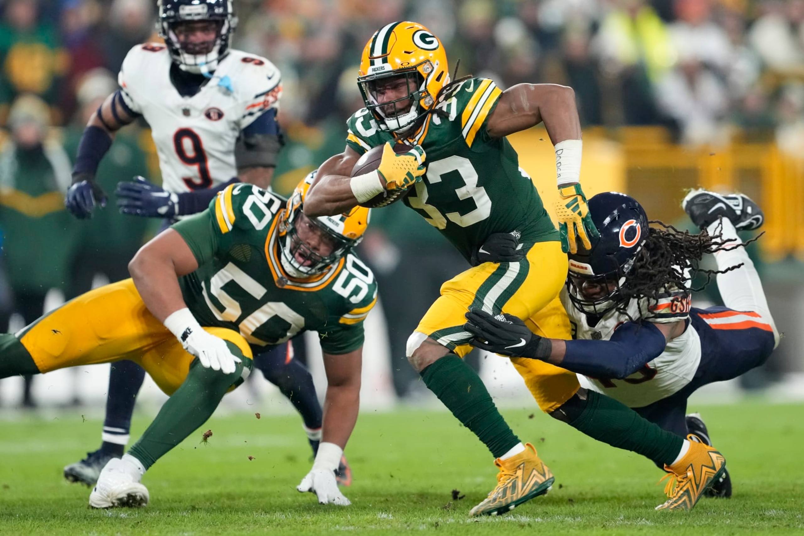 GREEN BAY, WISCONSIN - JANUARY 07: Aaron Jones #33 of the Green Bay Packers is tackled by Tremaine Edmunds #49 of the Chicago Bears during the third quarter at Lambeau Field on January 07, 2024 in Green Bay, Wisconsin. (Photo by Patrick McDermott/Getty Images)