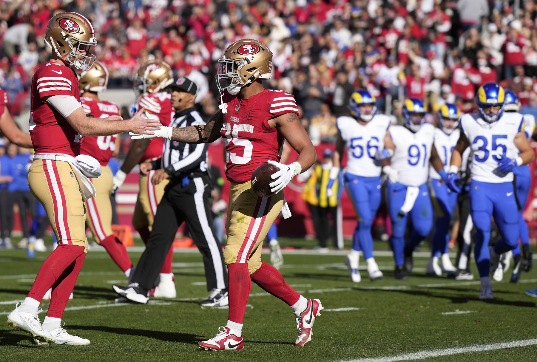 SANTA CLARA, CALIFORNIA - JANUARY 07: Sam Darnold #14 and Elijah Mitchell #25 of the San Francisco 49ers celebrate after a touchdown run in the first quarter during a game against the Los Angeles Rams at Levi's Stadium on January 07, 2024 in Santa Clara, California. (Photo by Thearon W. Henderson/Getty Images)