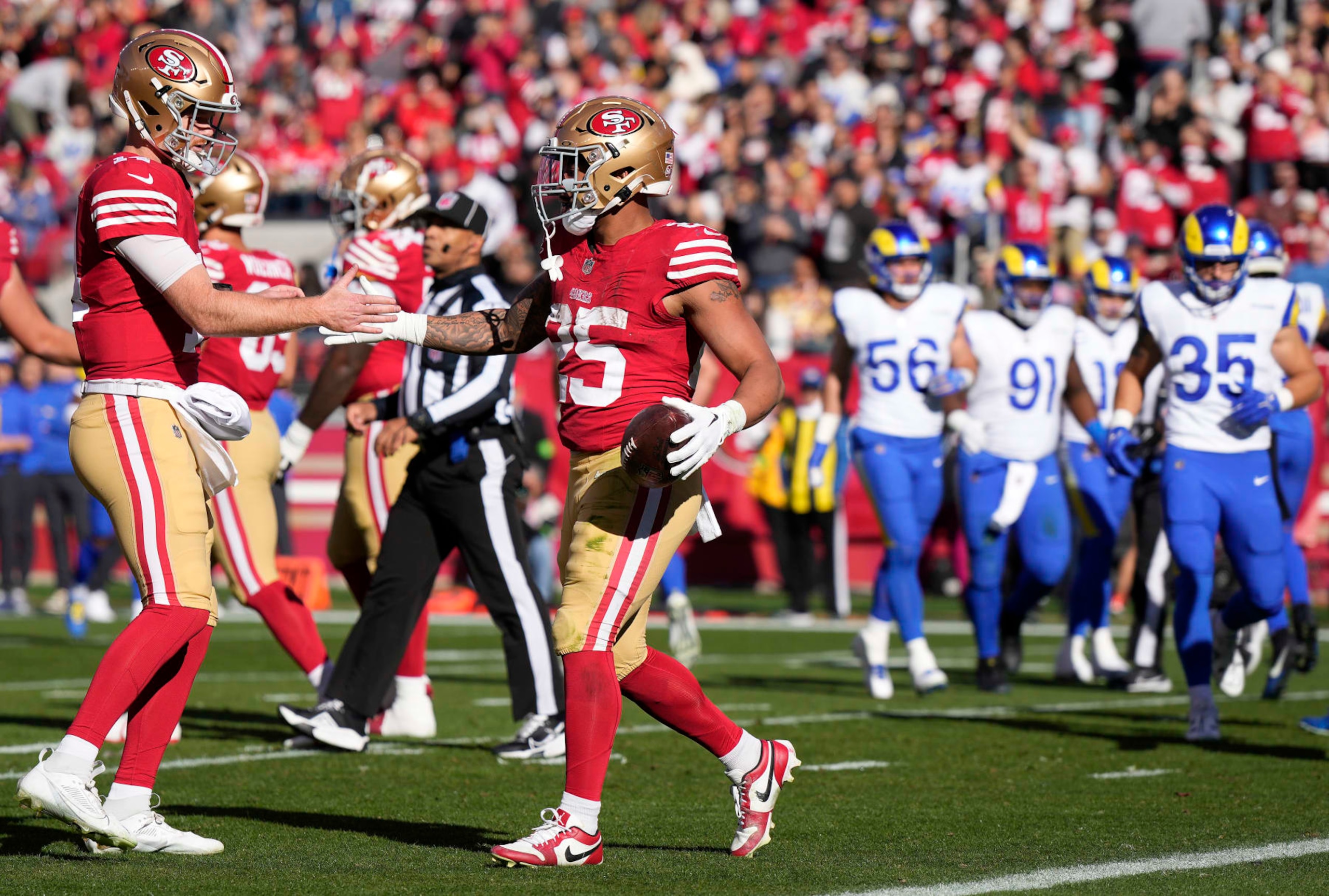 SANTA CLARA, CALIFORNIA - JANUARY 07: Sam Darnold #14 and Elijah Mitchell #25 of the San Francisco 49ers celebrate after a touchdown run in the first quarter during a game against the Los Angeles Rams at Levi's Stadium on January 07, 2024 in Santa Clara, California. (Photo by Thearon W. Henderson/Getty Images)