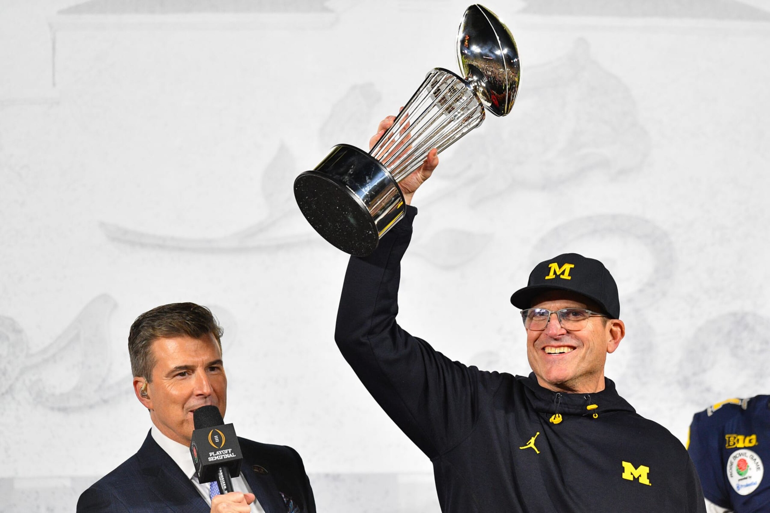 PASADENA, CA - JANUARY 01: Head Coach Jim Harbaugh of the Michigan Wolverines celebrates with the winners trophy after the Michigan Wolverines defeated the Alabama Crimson Tide in overtime of the CFP Semifinal at the Rose Bowl Game on January, 1, 2024, at the Rose Bowl Stadium in Pasadena, CA. (Photo by Chris Williams/Icon Sportswire via Getty Images)