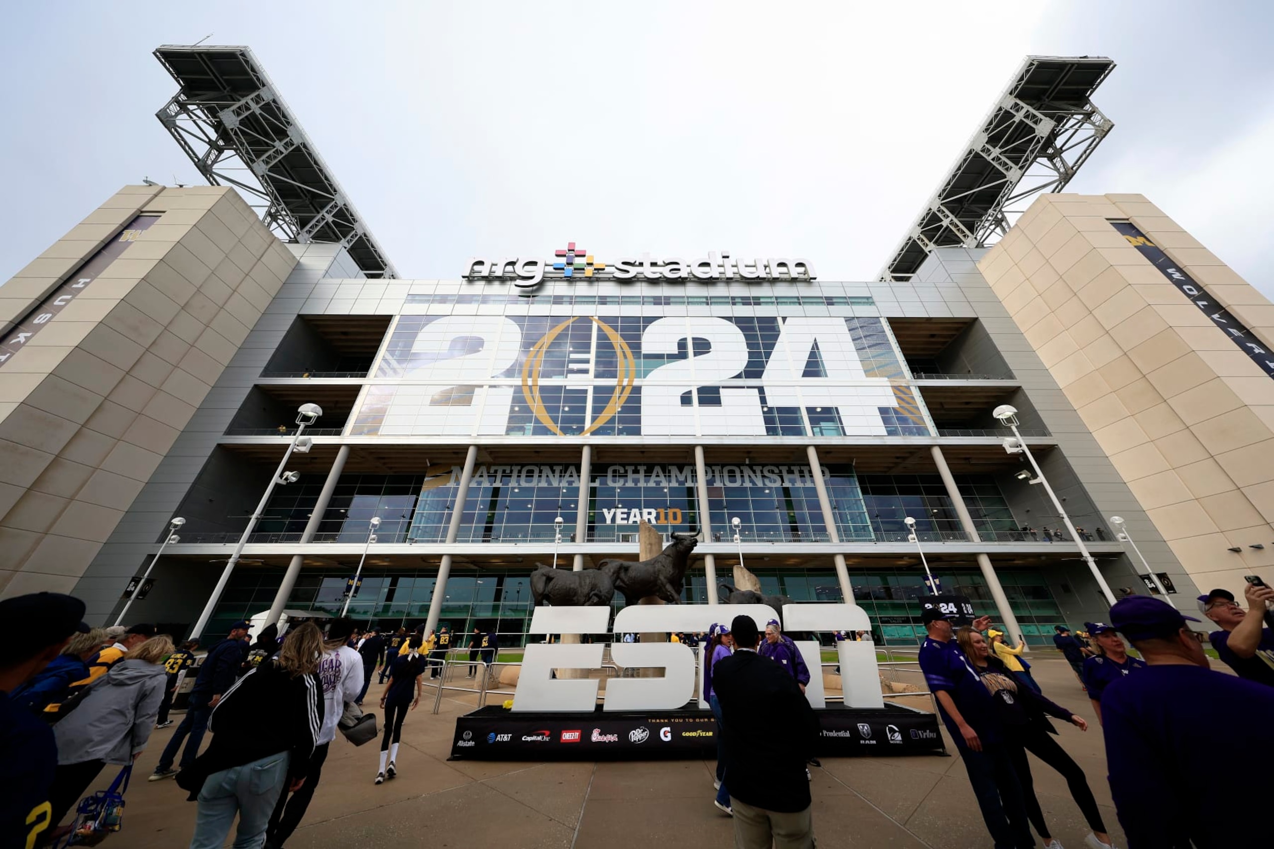 HOUSTON, TEXAS - JANUARY 08: Fans stand outside NRG Stadium prior to the 2024 CFP National Championship game between the Washington Huskies and Michigan Wolverines on January 08, 2024 in Houston, Texas. (Photo by Carmen Mandato/Getty Images)