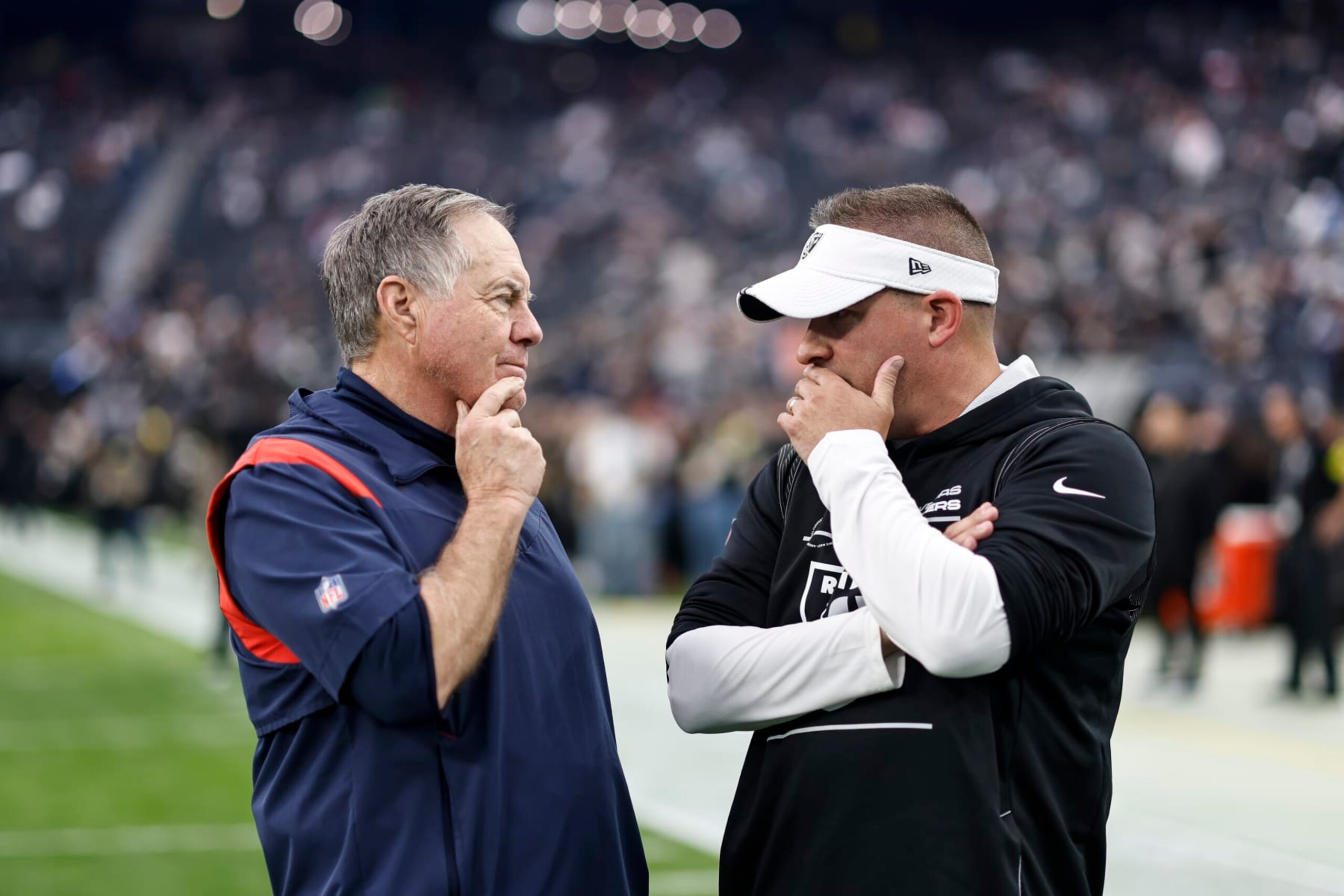 LAS VEGAS, NEVADA - DECEMBER 18: Head coach Bill Belichick of the New England Patriots and Head coach Josh McDaniels of the Las Vegas Raiders chat prior to an NFL football game between the Las Vegas Raiders and the New England Patriots at Allegiant Stadium on December 18, 2022 in Las Vegas, Nevada. (Photo by Michael Owens/Getty Images)
