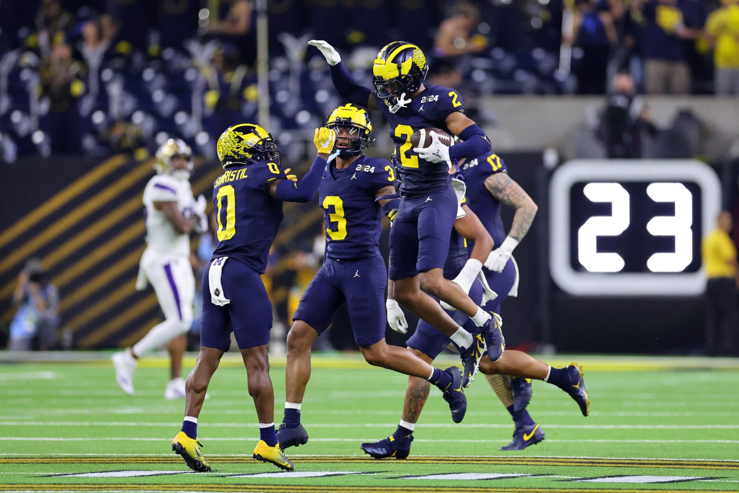 HOUSTON, TEXAS - JANUARY 08: Will Johnson #2 of the Michigan Wolverines clebrates with teammates after intercepting a pass in the third quarter against the Washington Huskies during the 2024 CFP National Championship game at NRG Stadium on January 08, 2024 in Houston, Texas. (Photo by Stacy Revere/Getty Images)