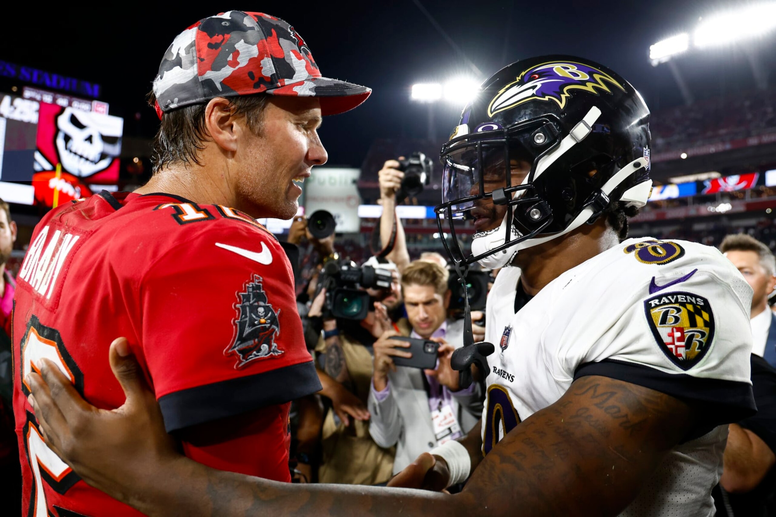 TAMPA, FLORIDA - OCTOBER 27: Tom Brady #12 of the Tampa Bay Buccaneers and Lamar Jackson #8 of the Baltimore Ravens meet on the field after their game at Raymond James Stadium on October 27, 2022 in Tampa, Florida. (Photo by Douglas P. DeFelice/Getty Images)