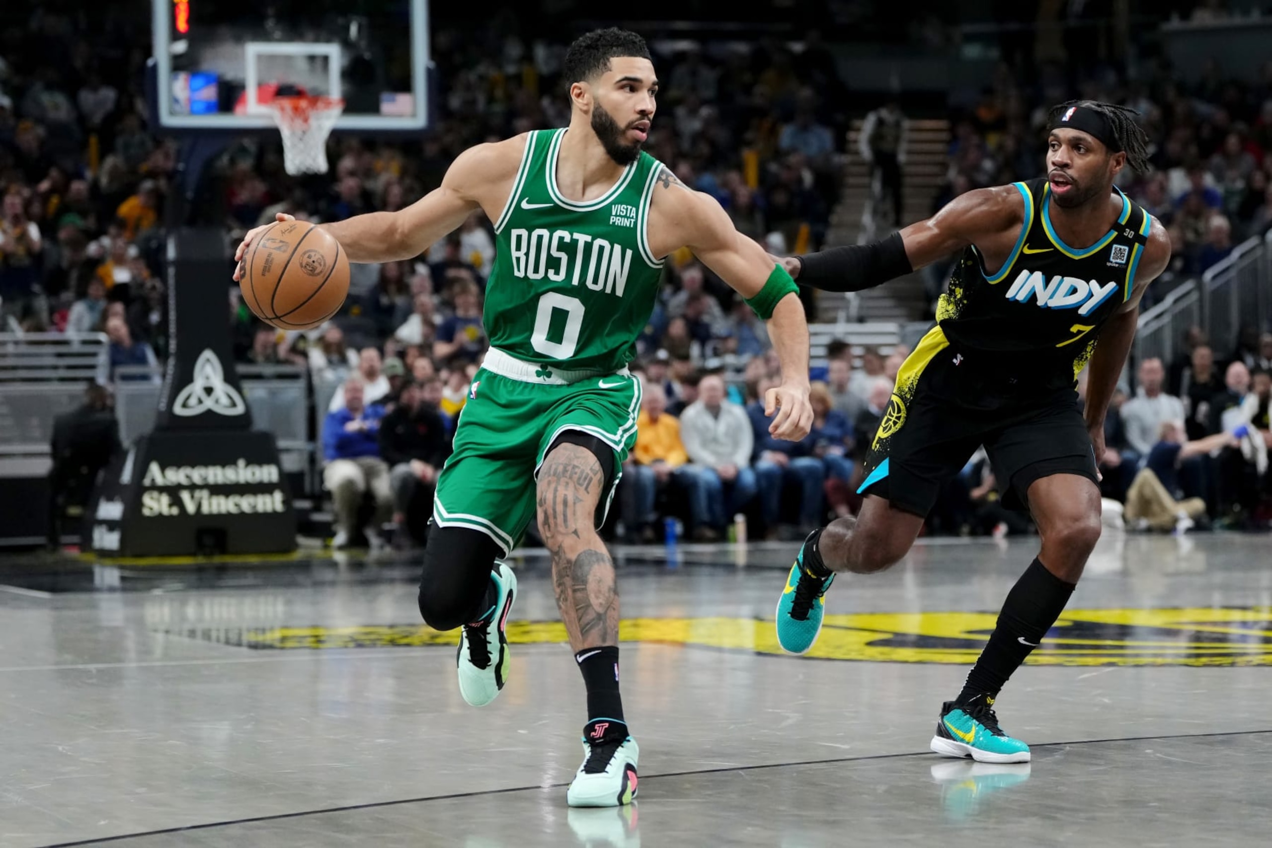 INDIANAPOLIS, INDIANA - JANUARY 06: Jayson Tatum #0 of the Boston Celtics dribbles the ball while being guarded by Buddy Hield #7 of the Indiana Pacers in the fourth quarter at Gainbridge Fieldhouse on January 06, 2024 in Indianapolis, Indiana. NOTE TO USER: User expressly acknowledges and agrees that, by downloading and or using this photograph, User is consenting to the terms and conditions of the Getty Images License Agreement. (Photo by Dylan Buell/Getty Images)