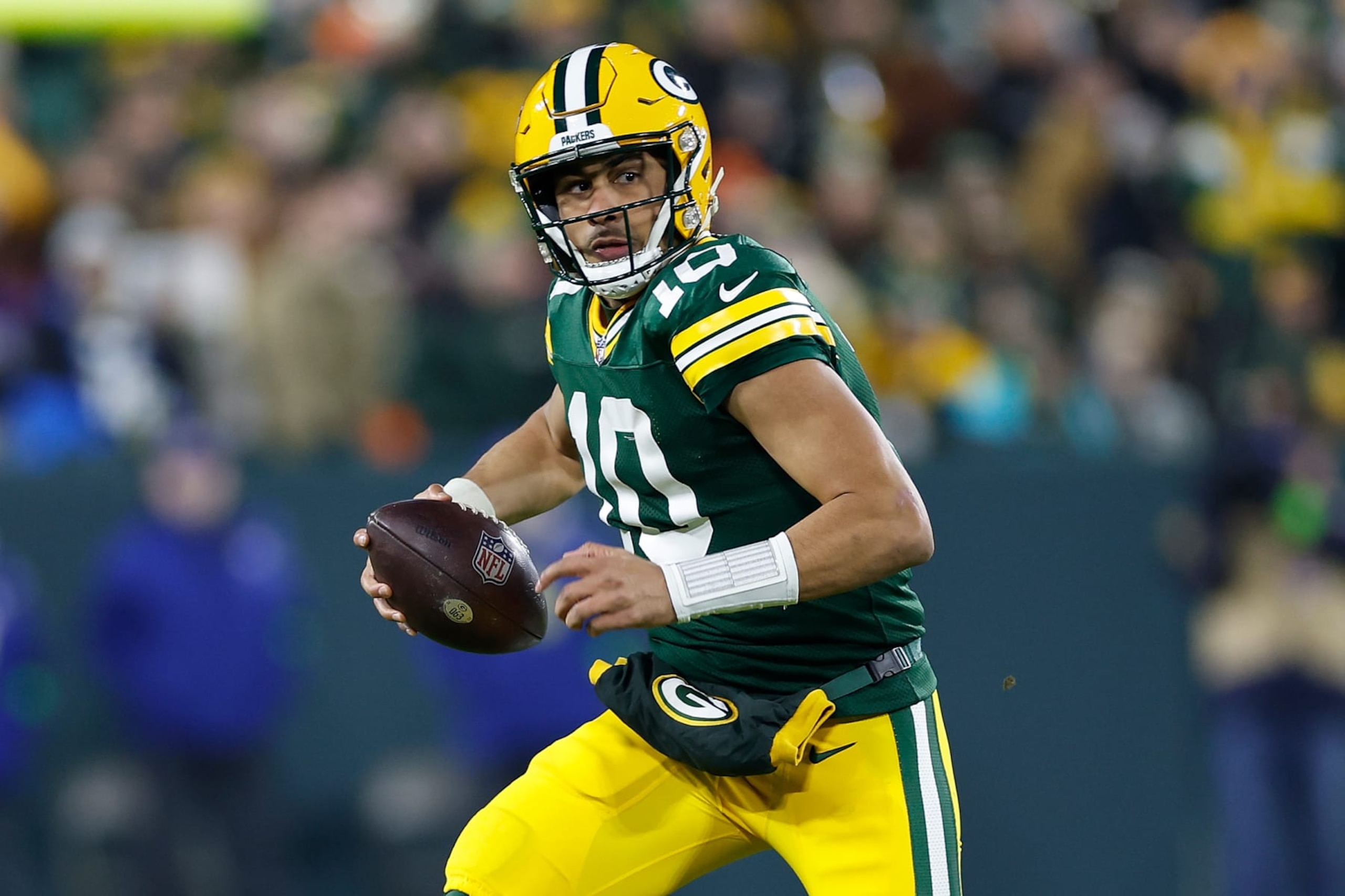 GREEN BAY, WISCONSIN - JANUARY 07: Jordan Love #10 of the Green Bay Packers carries the ball against the Chicago Bears at Lambeau Field on January 07, 2024 in Green Bay, Wisconsin. (Photo by John Fisher/Getty Images)