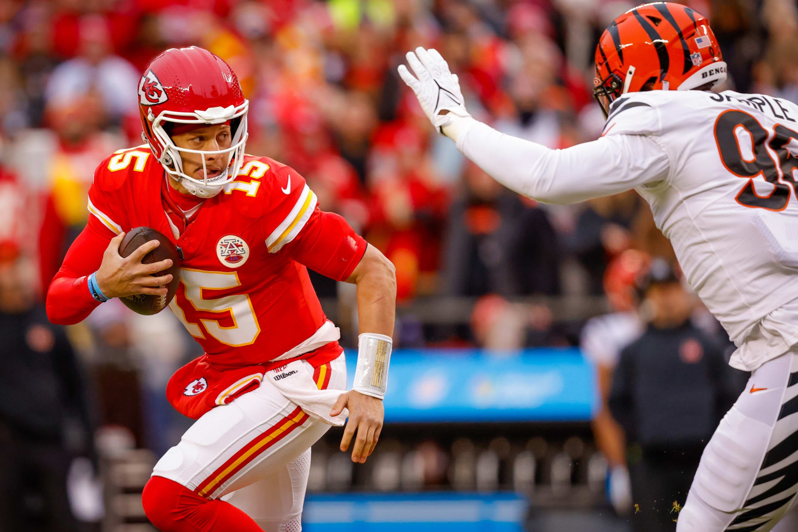 KANSAS CITY, MISSOURI - DECEMBER 31: Patrick Mahomes #15 of the Kansas City Chiefs runs from defensive pressure from Cam Sample #96 of the Cincinnati Bengals during the first quarter at GEHA Field at Arrowhead Stadium on December 31, 2023 in Kansas City, Missouri. (Photo by David Eulitt/Getty Images)