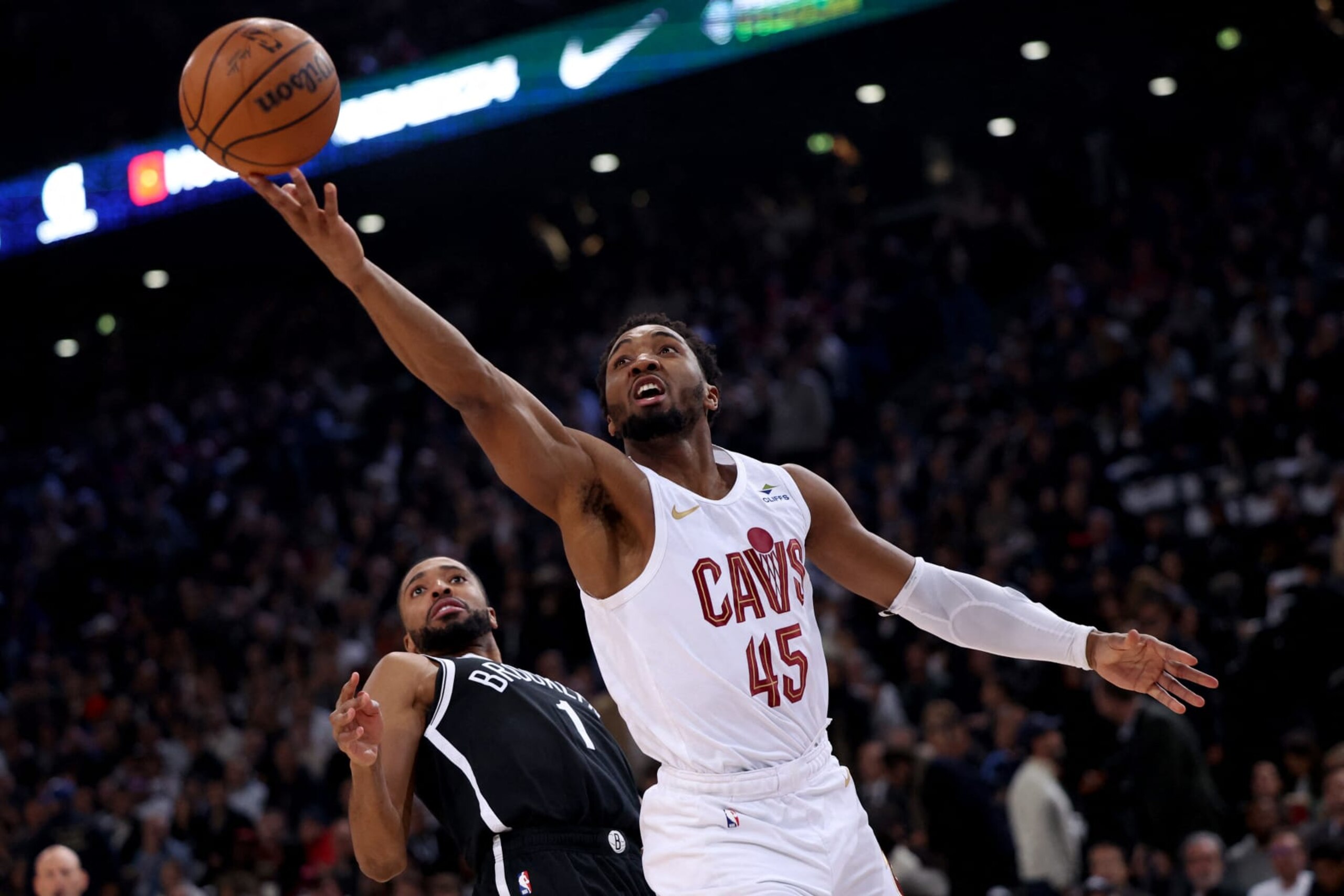 Cleveland Cavaliers' US Point Guard Donovan Mitchell (R) jumps to score in front of Brooklyn Nets' US Point Guard Mikal Bridges (L) during the NBA regular season basketball match between the Cleveland Cavaliers and the Brooklyn Nets at the Accor Arena in Paris on January 11, 2024. (Photo by Emmanuel Dunand / AFP) (Photo by EMMANUEL DUNAND/AFP via Getty Images)