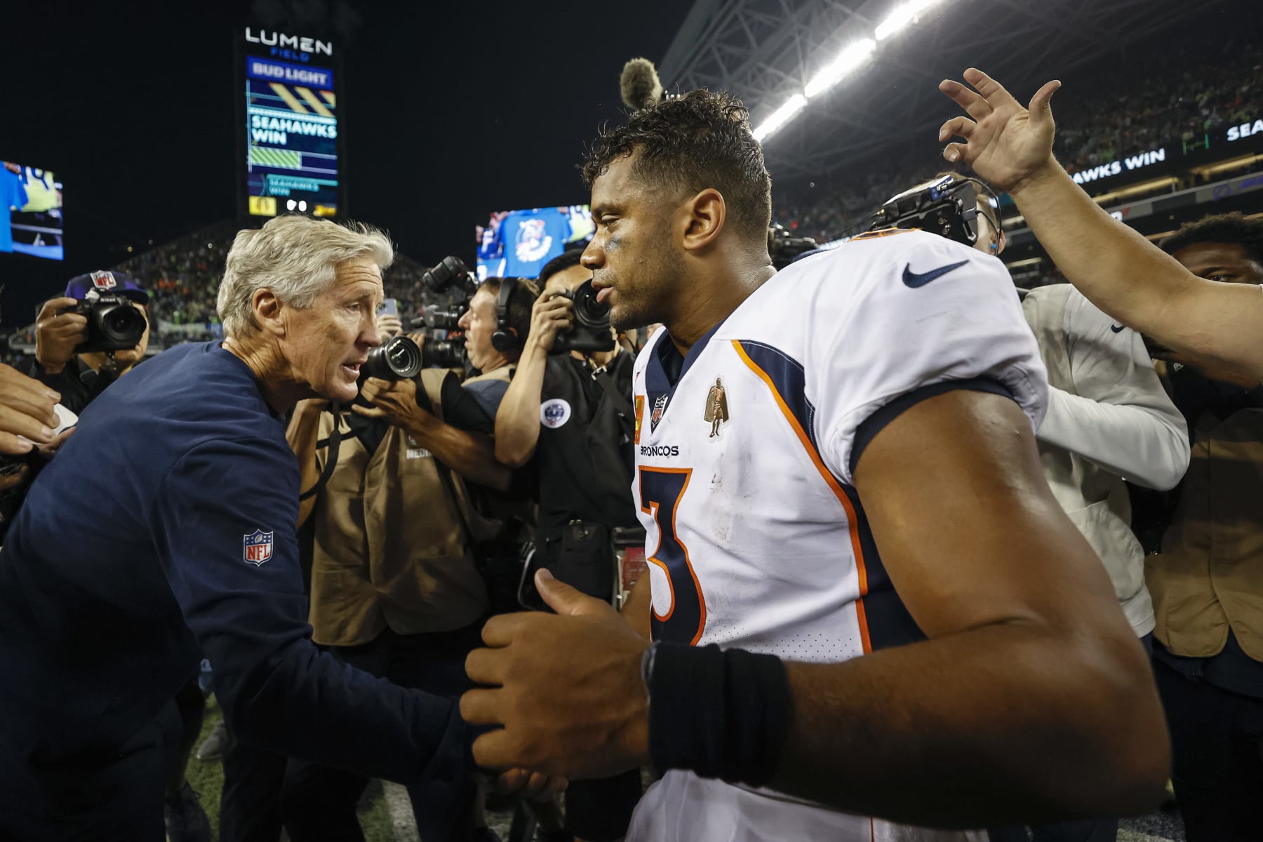 SEATTLE, WASHINGTON - SEPTEMBER 12: Head coach Pete Carroll of the Seattle Seahawks and Russell Wilson #3 of the Denver Broncos shake hands after their game at Lumen Field on September 12, 2022 in Seattle, Washington. (Photo by Steph Chambers/Getty Images)