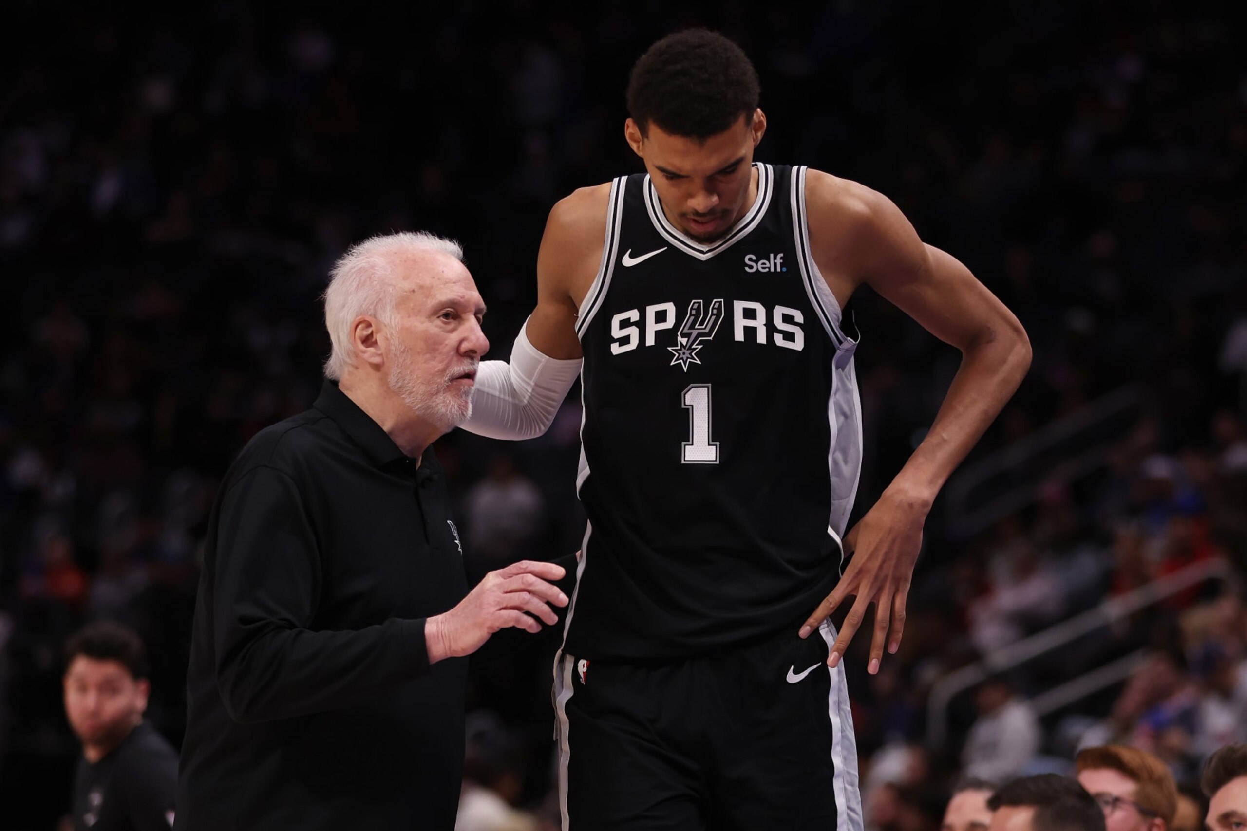 DETROIT, MICHIGAN - JANUARY 10: Head coach Gregg Popovich of the San Antonio Spurs talks to Victor Wembanyama #1 during the second half while playing the Detroit Pistons at Little Caesars Arena on January 10, 2024 in Detroit, Michigan. San Antonio Spurs won the game 130-108. NOTE TO USER: User expressly acknowledges and agrees that, by downloading and or using this photograph, User is consenting to the terms and conditions of the Getty Images License (Photo by Gregory Shamus/Getty Images) DETROIT, MICHIGAN - JANUARY 10: Head coach Gregg Popovich of the San Antonio Spurs talks to Victor Wembanyama #1 during the second half while playing the Detroit Pistons at Little Caesars Arena on January 10, 2024 in Detroit, Michigan. San Antonio Spurs won the game 130-108. NOTE TO USER: User expressly acknowledges and agrees that, by downloading and or using this photograph, User is consenting to the terms and conditions of the Getty Images License (Photo by Gregory Shamus/Getty Images)