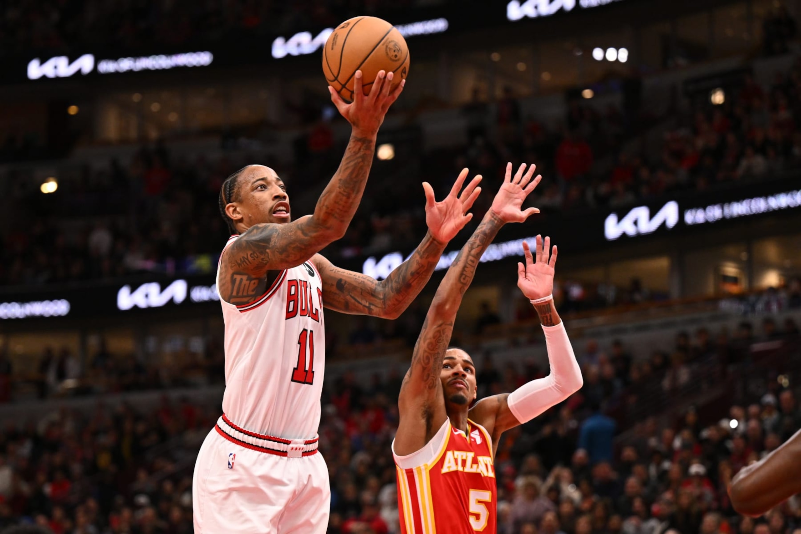 CHICAGO, ILLINOIS - DECEMBER 26:  DeMar DeRozan #11 of the Chicago Bulls drives in for a lay up past Dejounte Murray #5 of the Atlanta Hawks in the second half on December 26, 2023 at the United Center in Chicago, Illinois. Chicago defeated Atlanta 118-113.   NOTE TO USER: User expressly acknowledges and agrees that, by downloading and or using this photograph, User is consenting to the terms and conditions of the Getty Images License Agreement.  (Photo by Jamie Sabau/Getty Images)