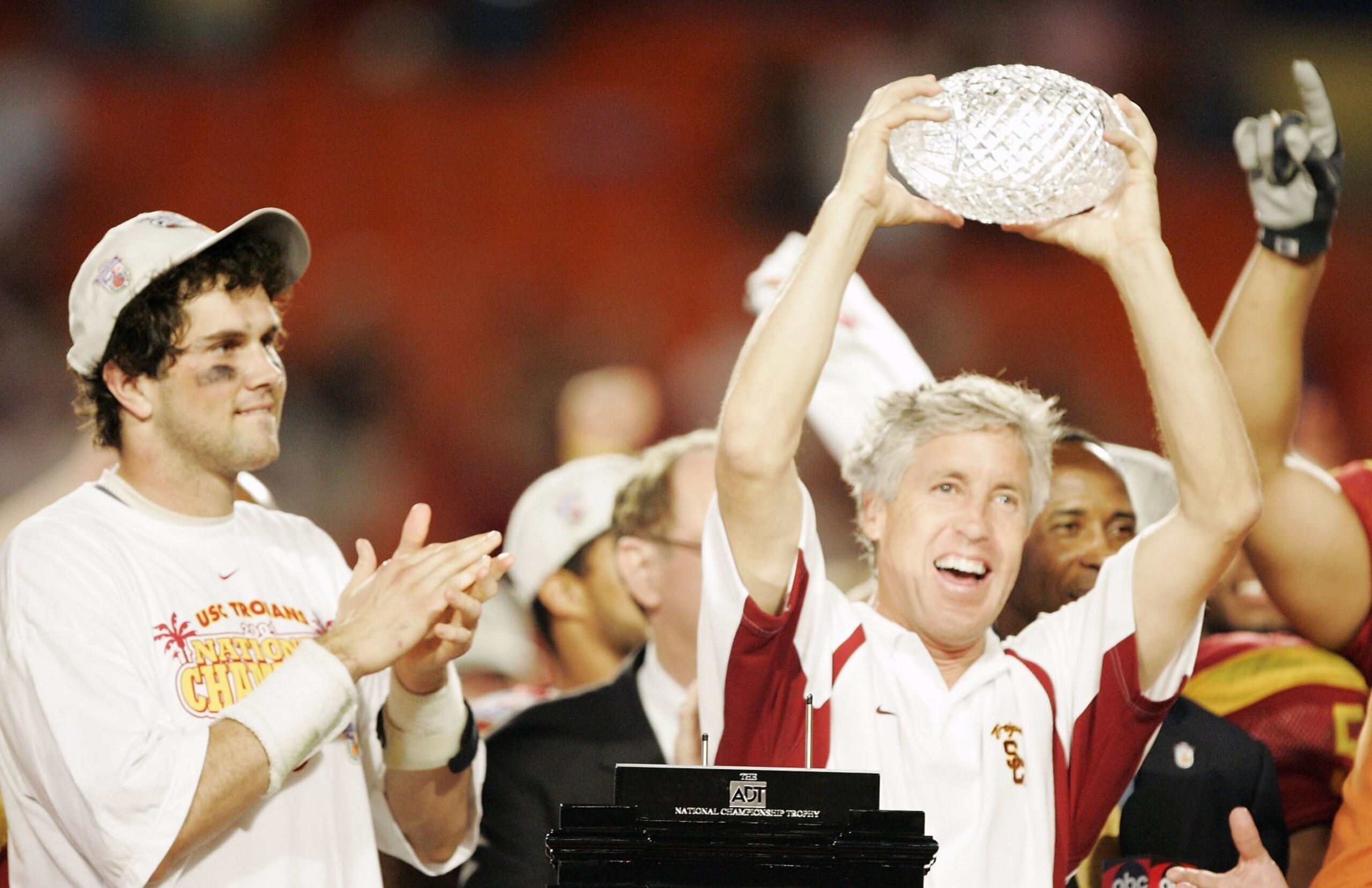 MIAMI - JANUARY 4:  Head coach Pete Carroll of the USC Trojans holds up the championship trophy as quarterback Matt Leinart #11 celebrates after defeating the Oklahoma Sooners 55-19 to win the FedEx Orange Bowl 2005 National Championship on January 4, 2005 at Pro Player Stadium in Miami, Florida.  (Photo by Brian Bahr/Getty Images)