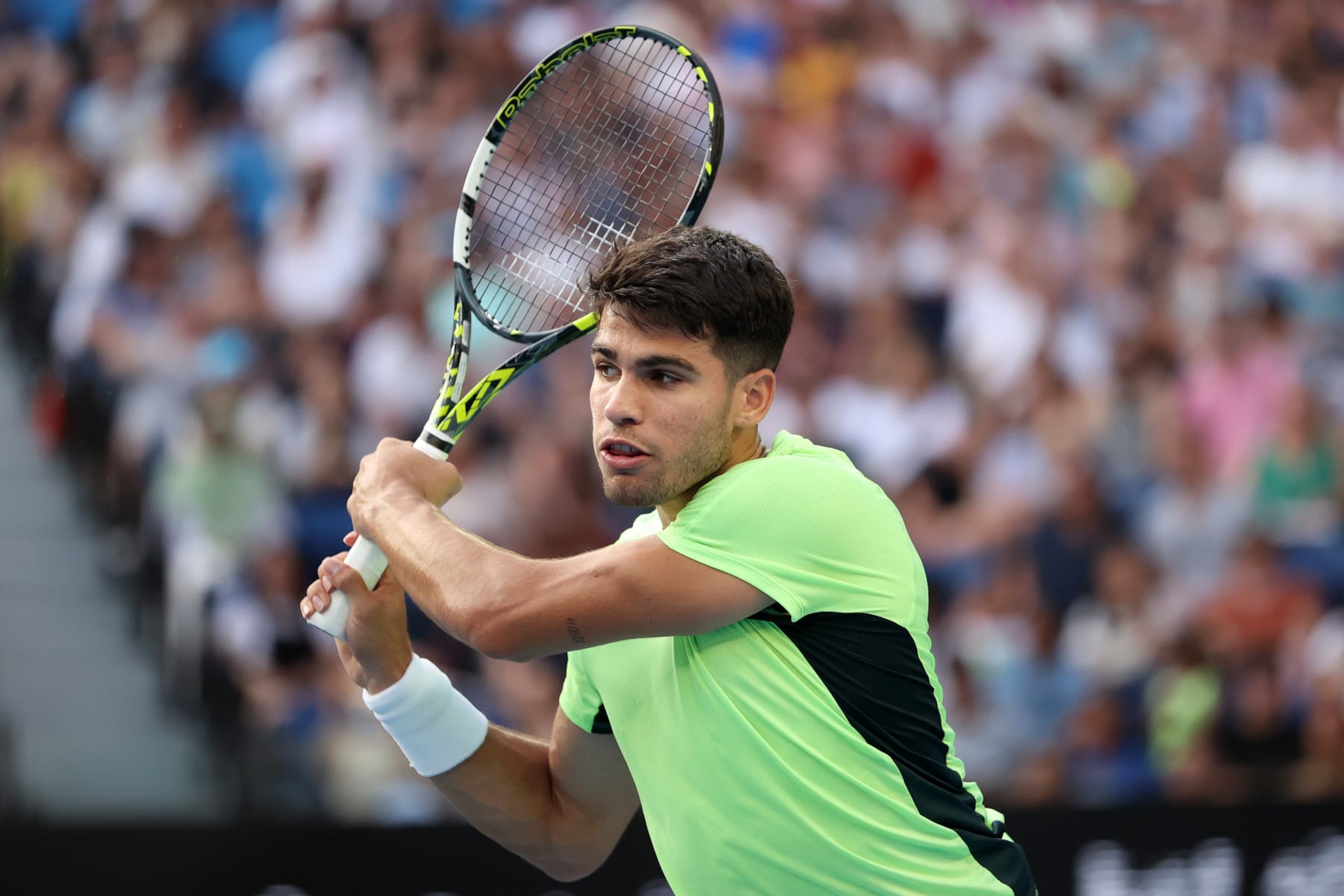 MELBOURNE, AUSTRALIA - JANUARY 12: Carlos Alcaraz of Spain plays a backhand in an exhibition match against Casper Ruud of Norway ahead of the 2024 Australian Open at Melbourne Park on January 12, 2024 in Melbourne, Australia. (Photo by Kelly Defina/Getty Images)
