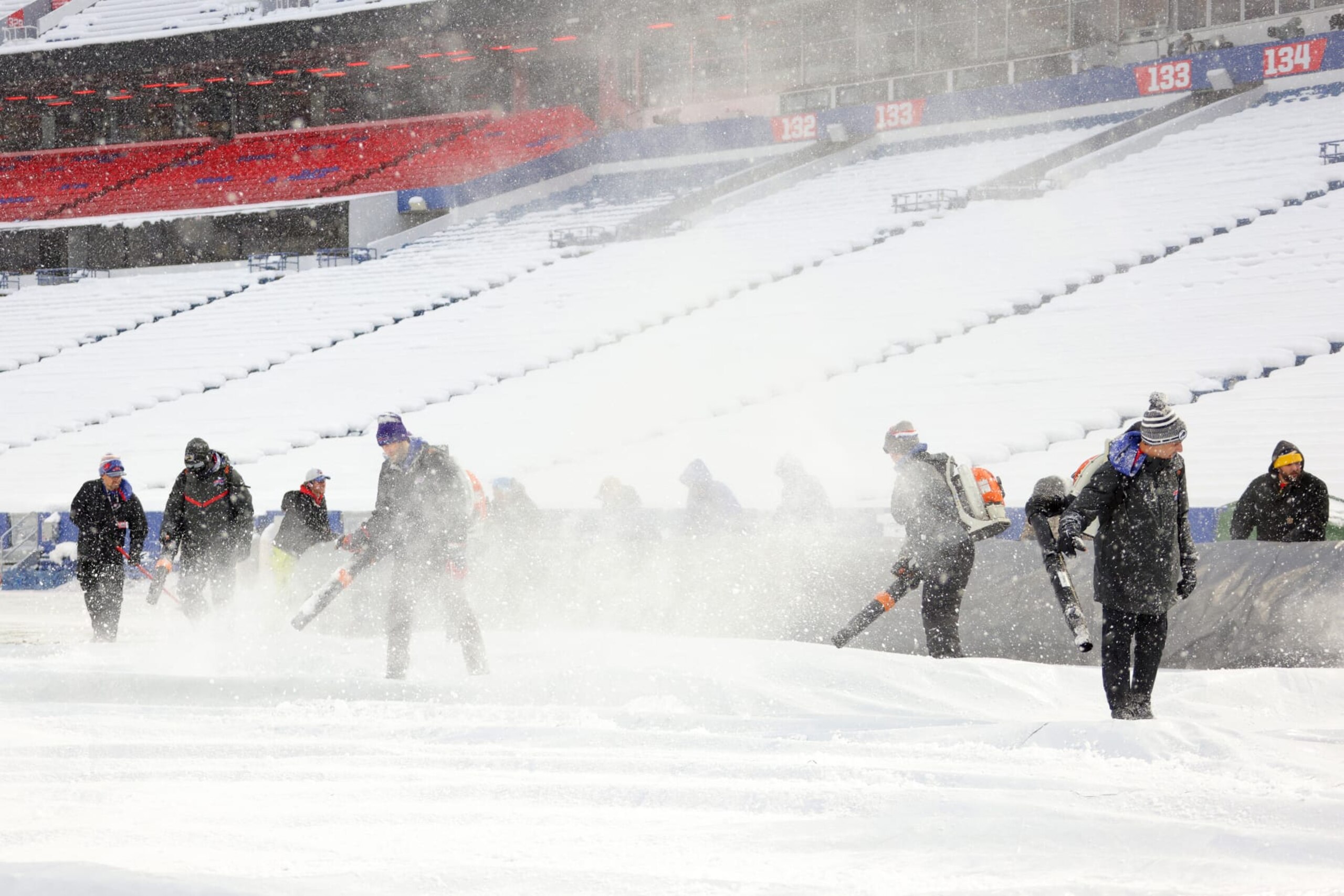 ORCHARD PARK, NEW YORK - DECEMBER 17: Stadium workers clear snow off the field prior to a game between the Miami Dolphins and Buffalo Bills at Highmark Stadium on December 17, 2022 in Orchard Park, New York. (Photo by Timothy T Ludwig/Getty Images)