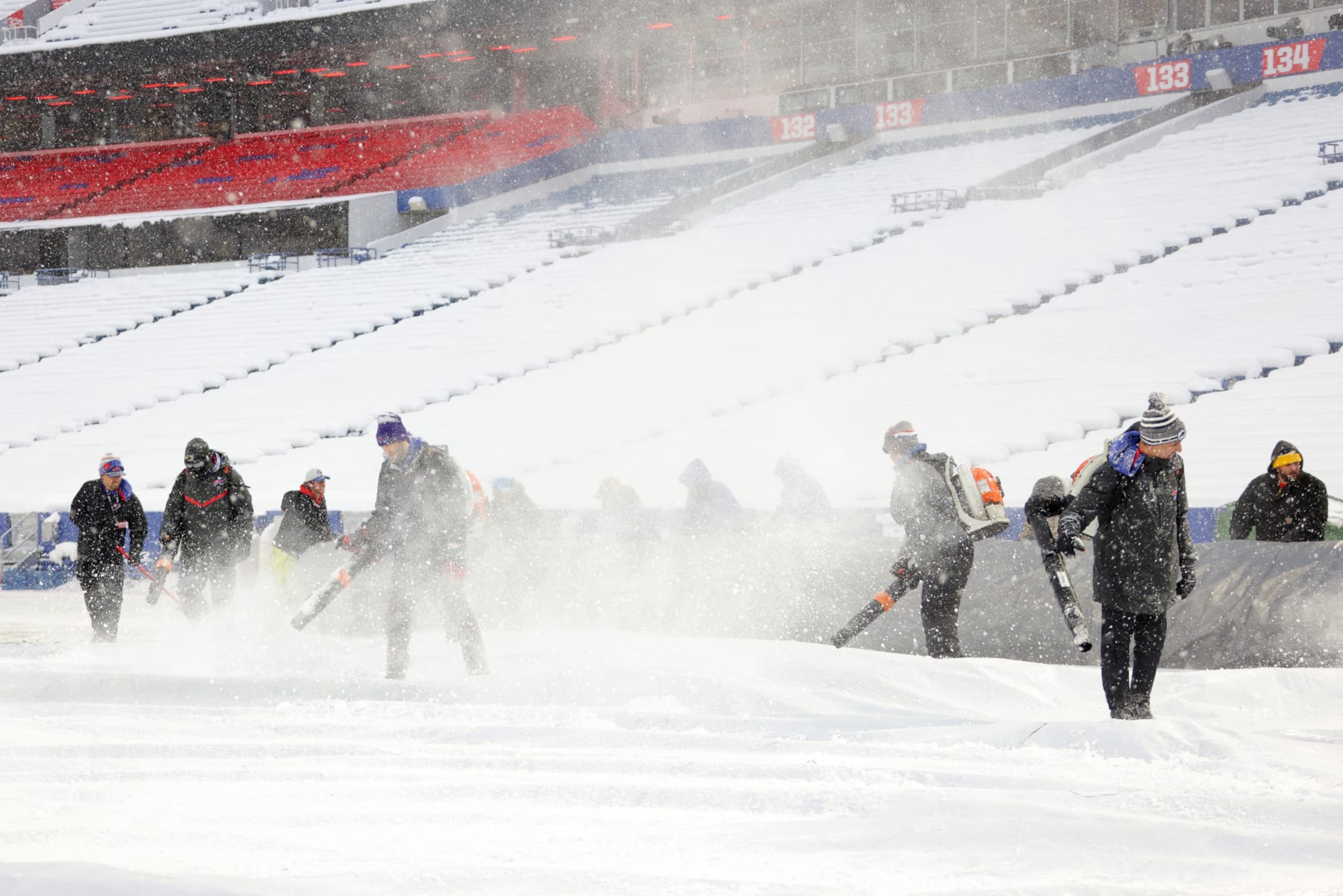 ORCHARD PARK, NEW YORK - DECEMBER 17: Stadium workers clear snow off the field prior to a game between the Miami Dolphins and Buffalo Bills at Highmark Stadium on December 17, 2022 in Orchard Park, New York. (Photo by Timothy T Ludwig/Getty Images)