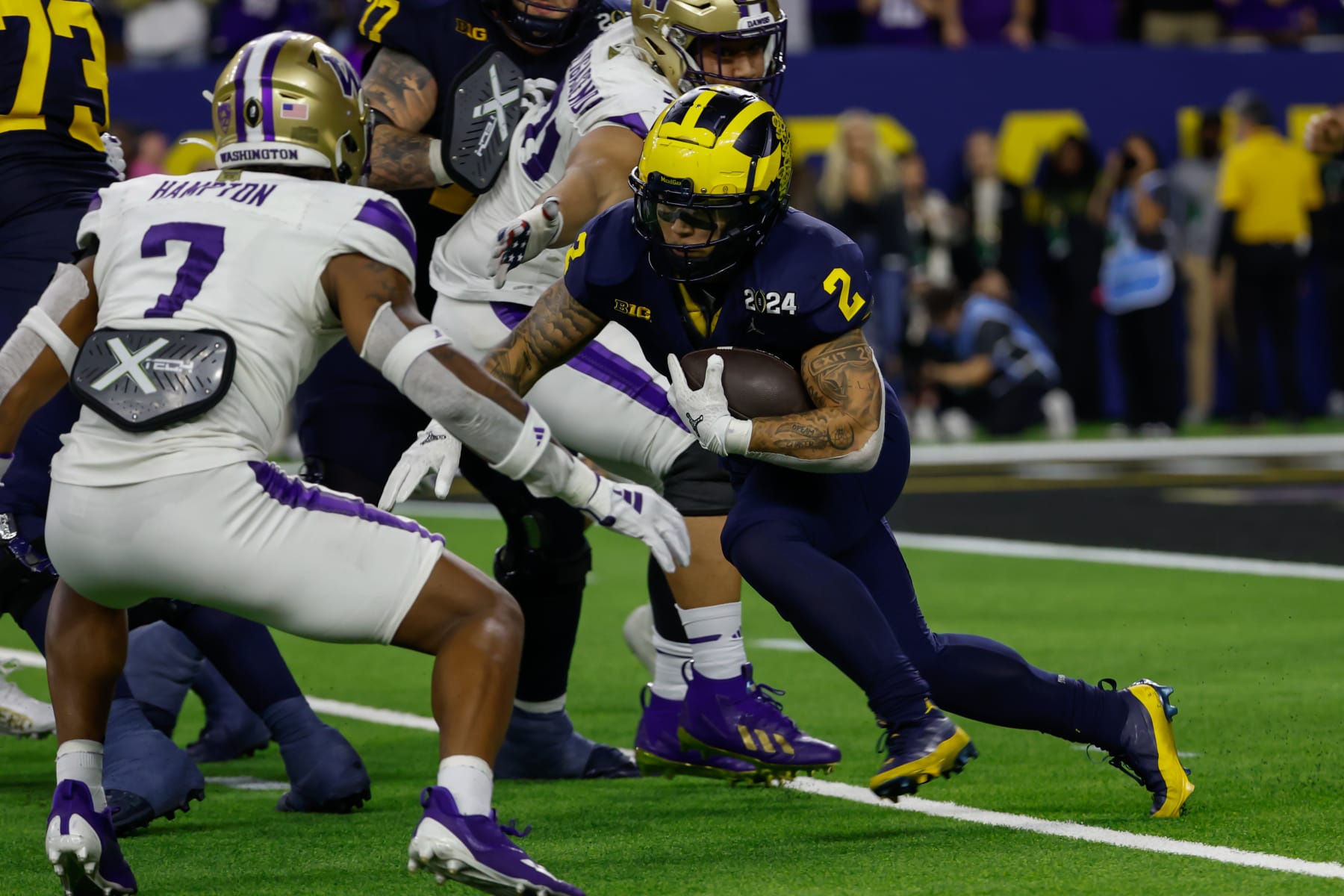 HOUSTON, TX - JANUARY 08: Michigan Wolverines running back Blake Corum (2) runs with the ball while Washington Huskies cornerback Dominique Hampton (7) lines him up for a tackle during the CFP National Championship game Michigan Wolverines and Washington Huskies on January 8, 2024, at NRG Stadium in Houston, Texas. (Photo by David Buono/Icon Sportswire via Getty Images)