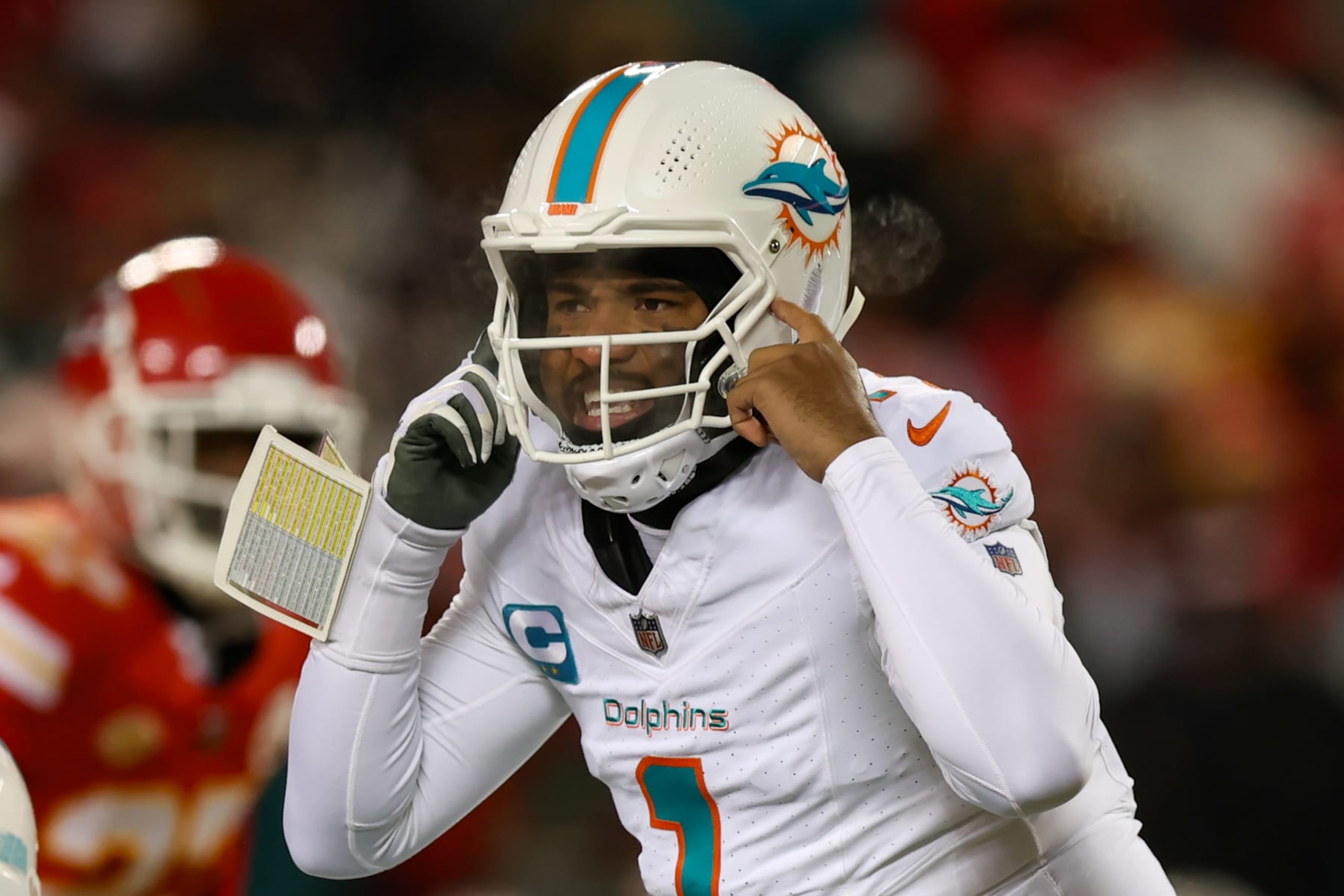 KANSAS CITY, MO - JANUARY 13: Miami Dolphins quarterback Tua Tagovailoa (1) points to his helmet before the snap in the first quarter of an AFC Wild Card playoff game between the Miami Dolphins and Kansas City Chiefs on Jan 13, 2024 at GEHA Field at Arrowhead Stadium in Kansas City, MO. (Photo by Scott Winters/Icon Sportswire via Getty Images)