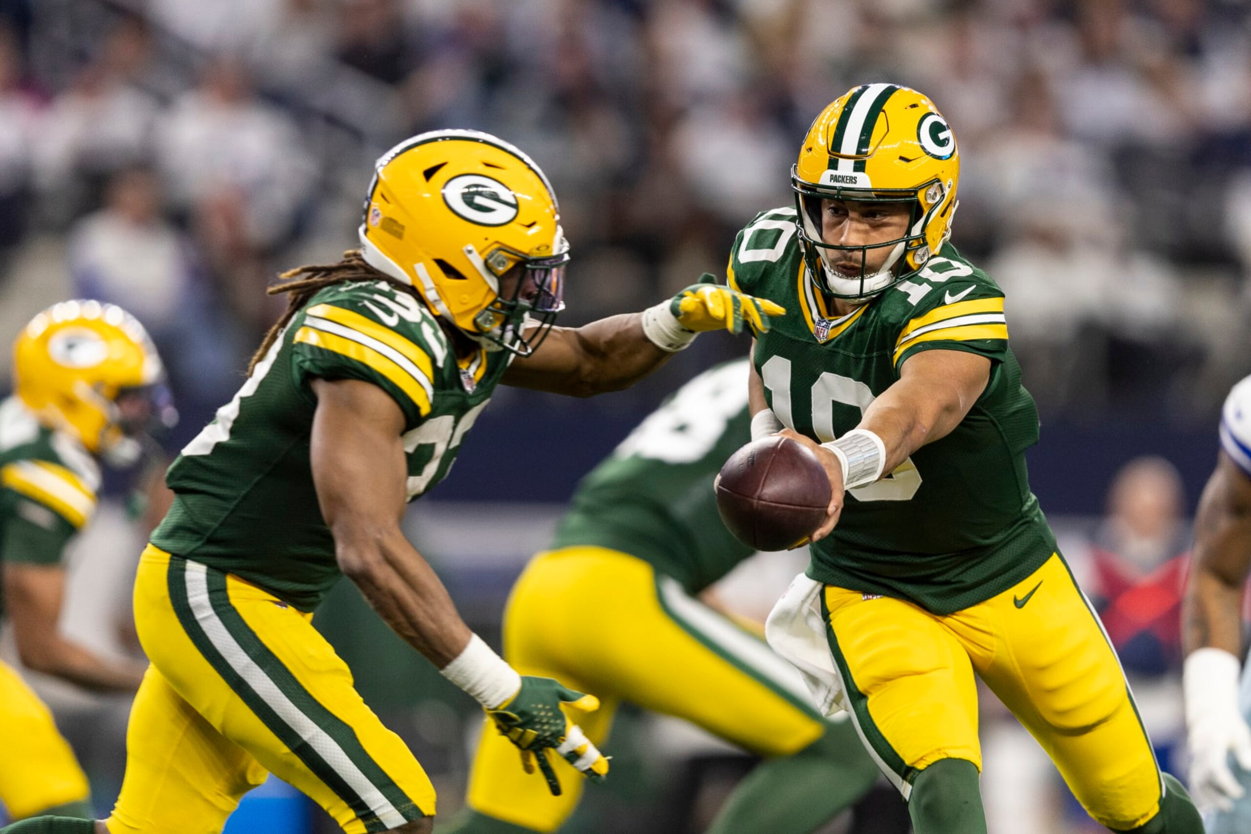 ARLINGTON, TEXAS - JANUARY 14: Jordan Love #10 of the Green Bay Packers hands the ball off to Aaron Jones #33 of the Green Bay Packers during an NFL wild-card playoff football game between the Dallas Cowboys and the Green Bay Packers at AT&T Stadium on January 14, 2024 in Arlington, Texas. (Photo by Michael Owens/Getty Images)