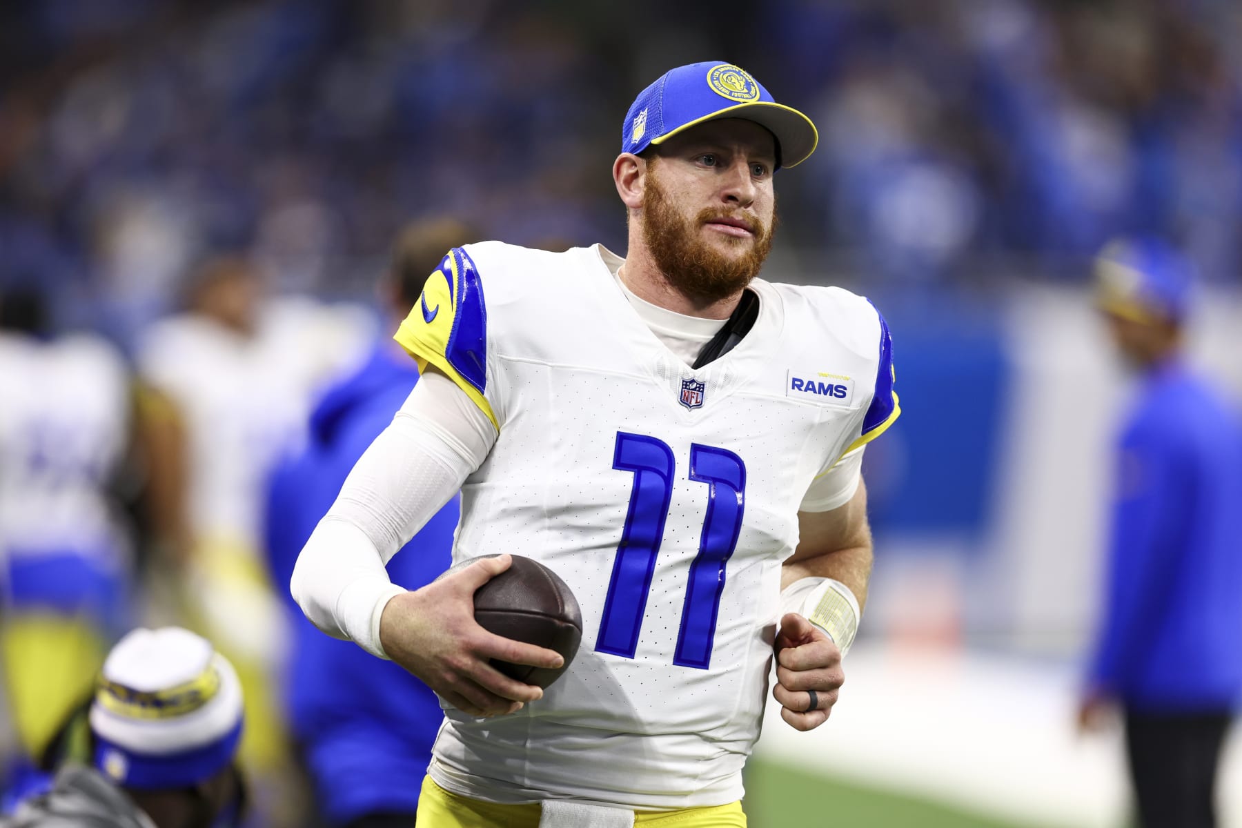 DETROIT, MI - JANUARY 14: Carson Wentz #11 of the Los Angeles Rams warms up on the sidelines during an NFL wild-card playoff football game against the Detroit Lions at Ford Field on January 14, 2024 in Detroit, Michigan. (Photo by Kevin Sabitus/Getty Images)