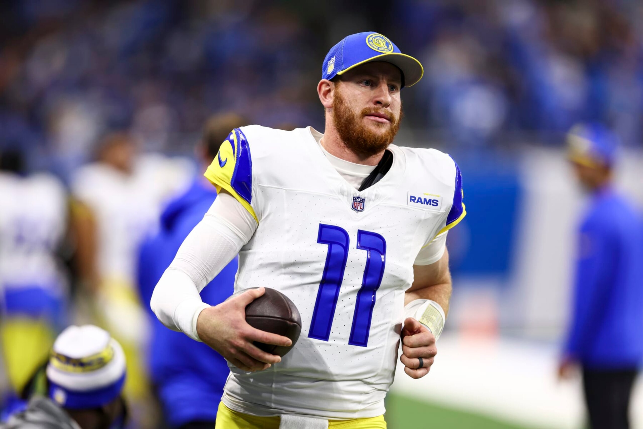 DETROIT, MI - JANUARY 14: Carson Wentz #11 of the Los Angeles Rams warms up on the sidelines during an NFL wild-card playoff football game against the Detroit Lions at Ford Field on January 14, 2024 in Detroit, Michigan. (Photo by Kevin Sabitus/Getty Images)
