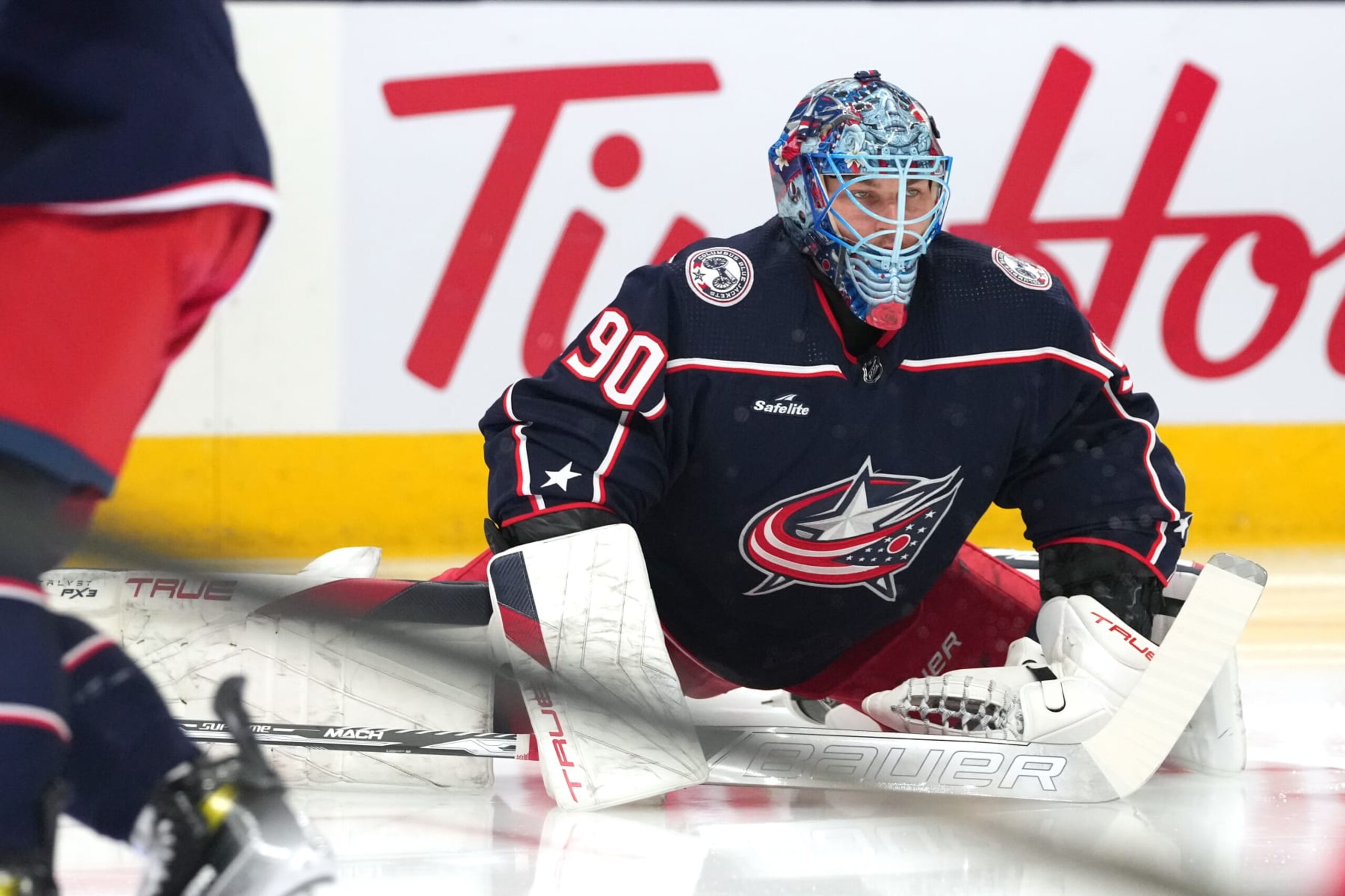 COLUMBUS, OHIO - JANUARY 15: Elvis Merzlikins #90 of the Columbus Blue Jackets stretches during warms up prior to a game against the Vancouver Canucks at Nationwide Arena on January 15, 2024 in Columbus, Ohio. (Photo by Jason Mowry/Getty Images)