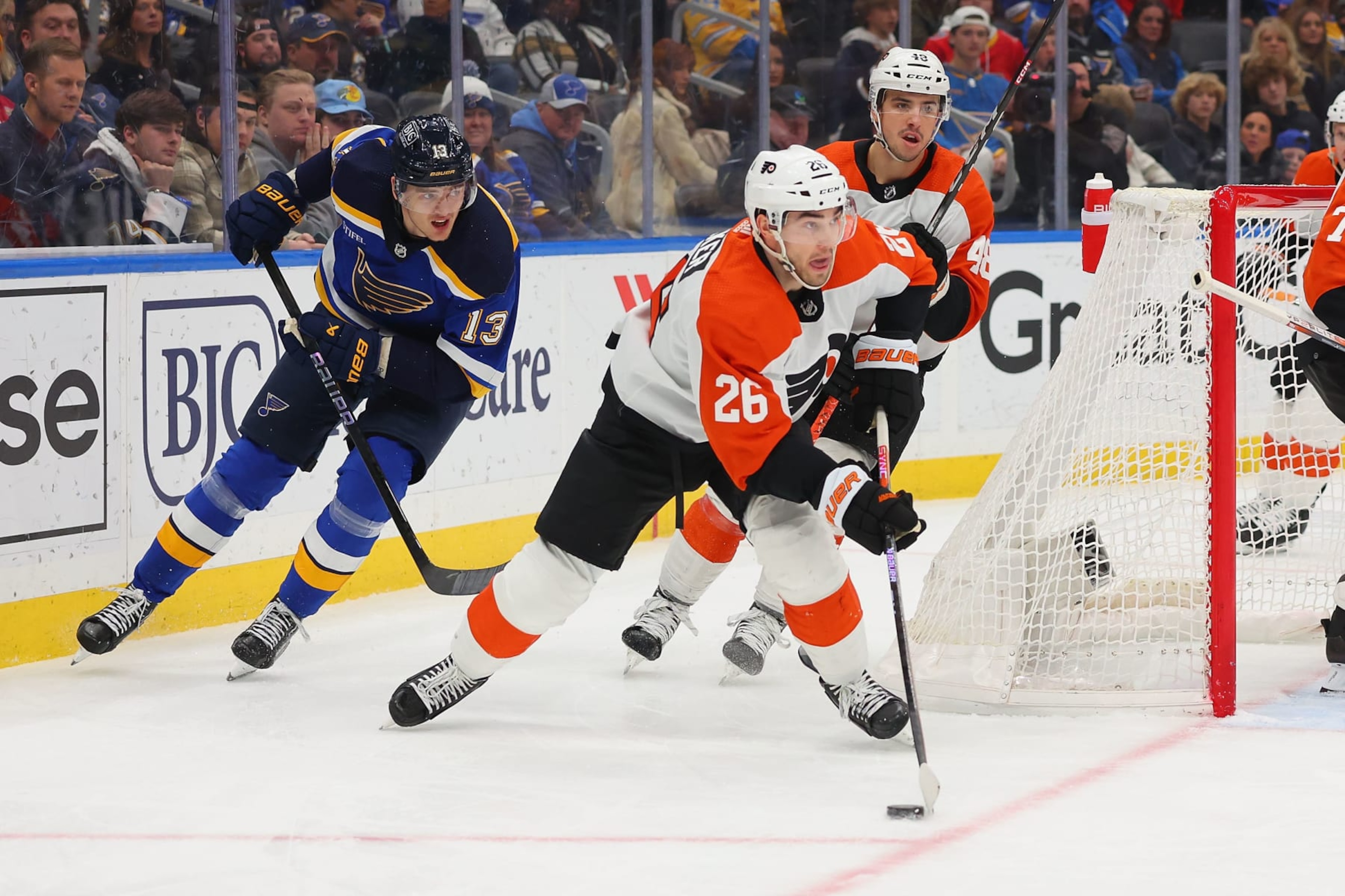 ST LOUIS, MISSOURI - JANUARY 15: Sean Walker #26 of the Philadelphia Flyers looks to clear the puck against Alexey Toropchenko #13 of the St. Louis Blues in the third period at Enterprise Center on January 15, 2024 in St Louis, Missouri. (Photo by Dilip Vishwanat/Getty Images)