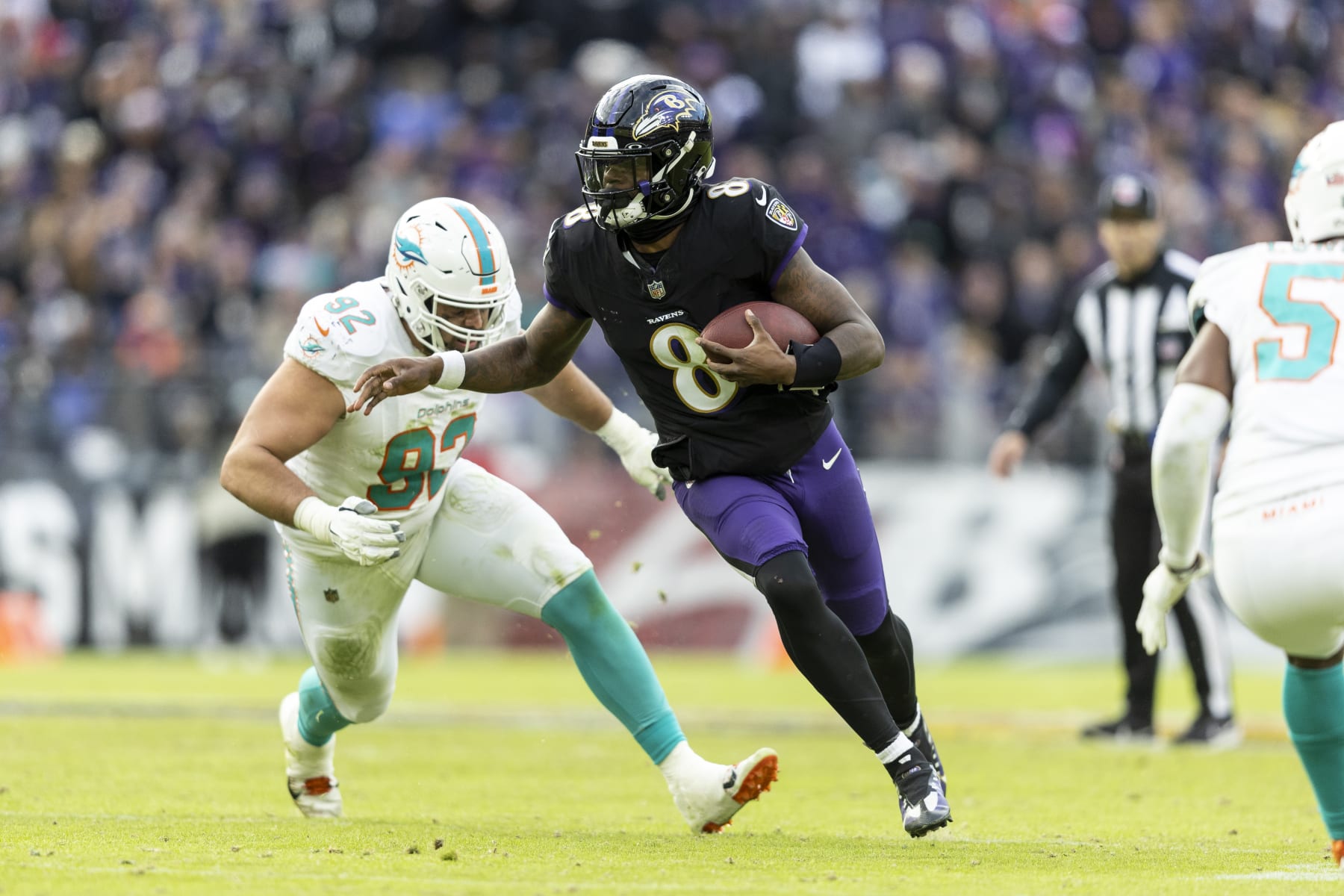 BALTIMORE, MARYLAND - DECEMBER 31: Lamar Jackson #8 of the Baltimore Ravens scrambles and runs with the ball during an NFL football game between the Baltimore Ravens and the Miami Dolphins at M&T Bank Stadium on December 31, 2023 in Baltimore, Maryland. (Photo by Michael Owens/Getty Images)
