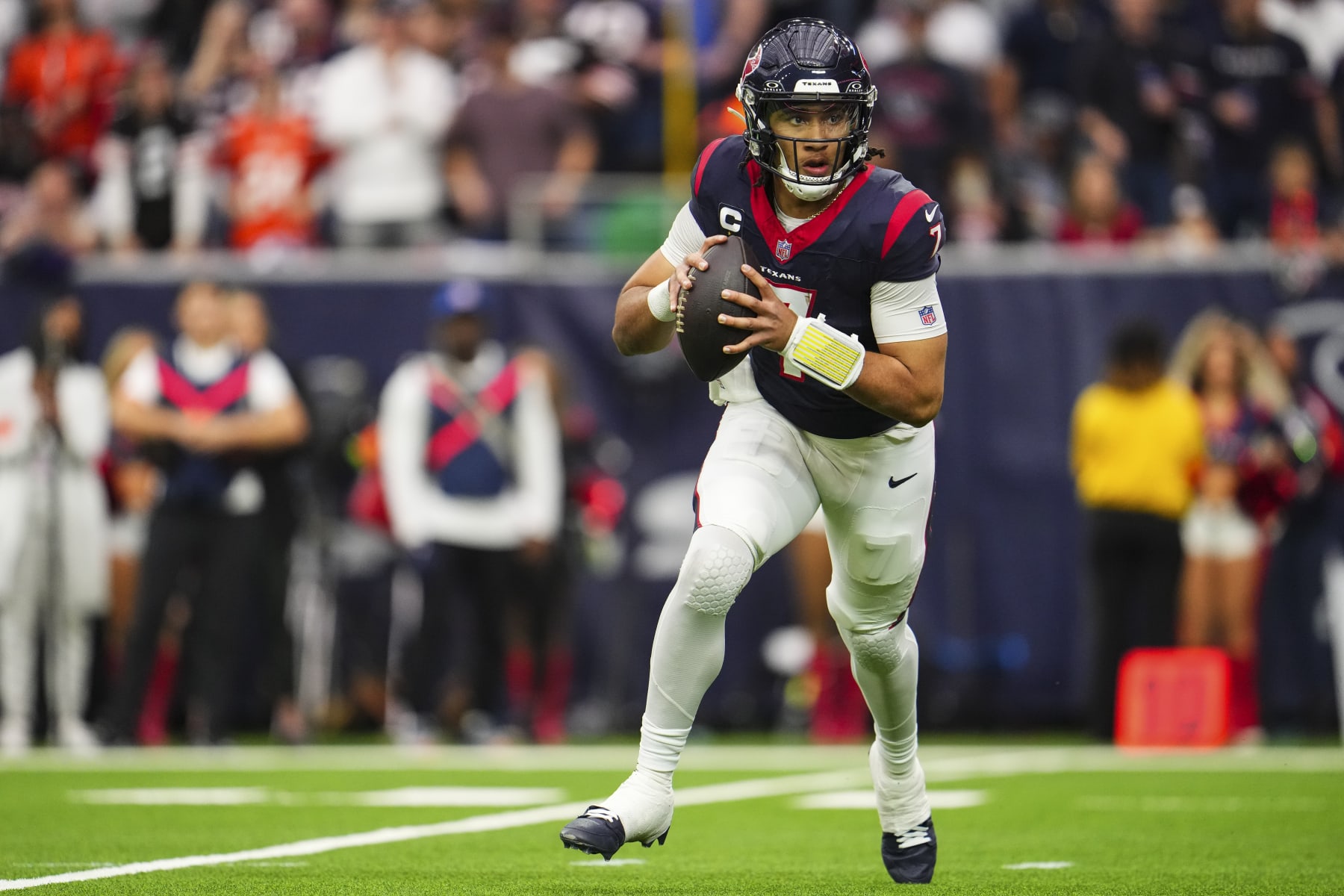 HOUSTON, TX - JANUARY 13: C.J. Stroud #7 of the Houston Texans scrambles out of the pocket during an NFL wild-card playoff football game against the Cleveland Browns at NRG Stadium on January 13, 2024 in Houston, Texas. (Photo by Cooper Neill/Getty Images)