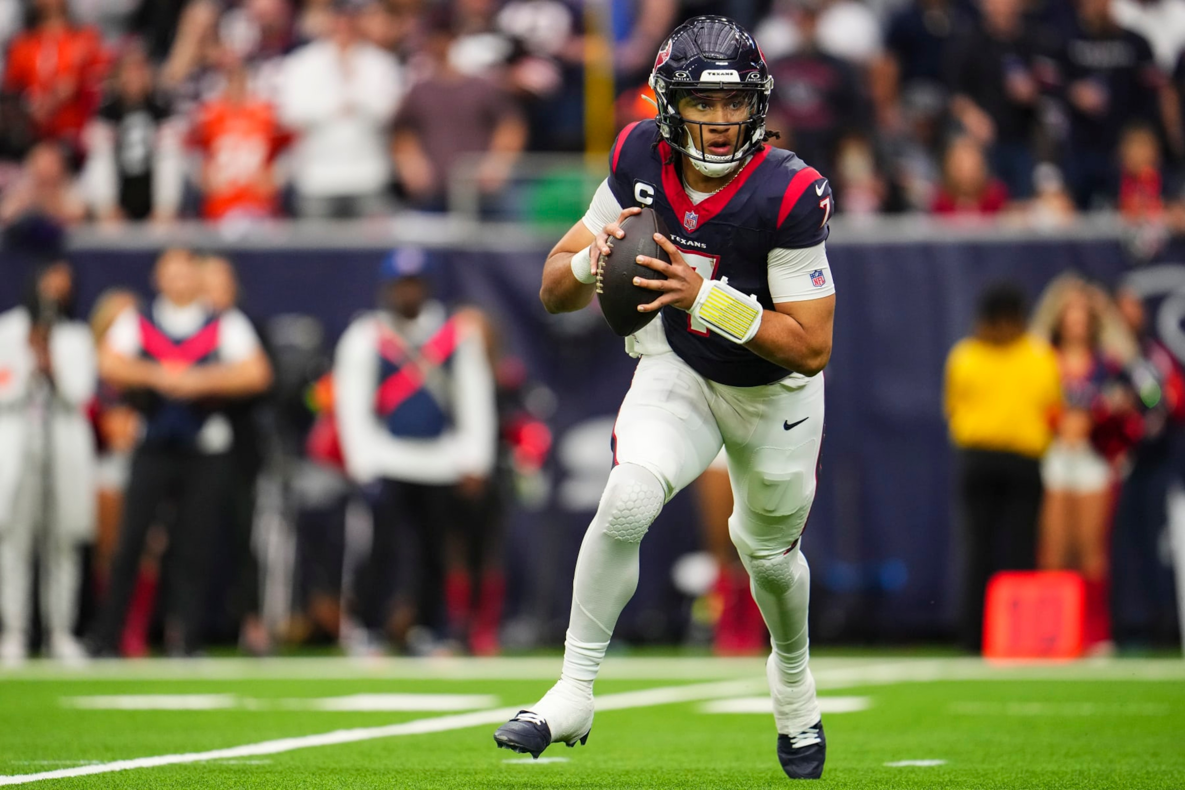 HOUSTON, TX - JANUARY 13: C.J. Stroud #7 of the Houston Texans scrambles out of the pocket during an NFL wild-card playoff football game against the Cleveland Browns at NRG Stadium on January 13, 2024 in Houston, Texas. (Photo by Cooper Neill/Getty Images)