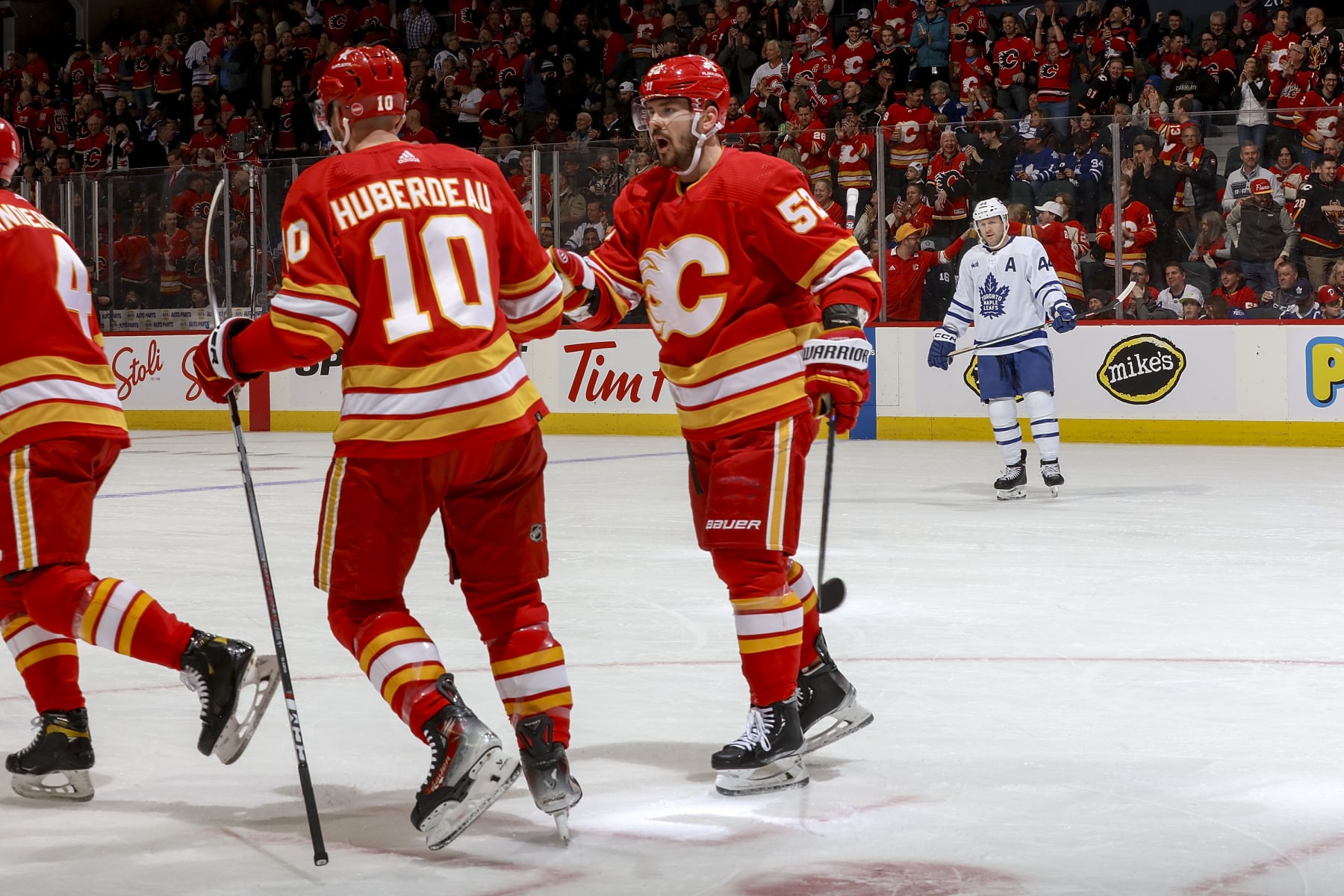 CALGARY, AB - JANUARY 18: Jonathan Huberdeau #10 and MacKenzie Weegar #52 of the Calgary Flames celebrate on ice after a goal against the Toronto Maple Leafs at Scotiabank Saddledome on January 18, 2024 in Calgary, Alberta, Canada. (Photo by Gerry Thomas/NHLI via Getty Images)