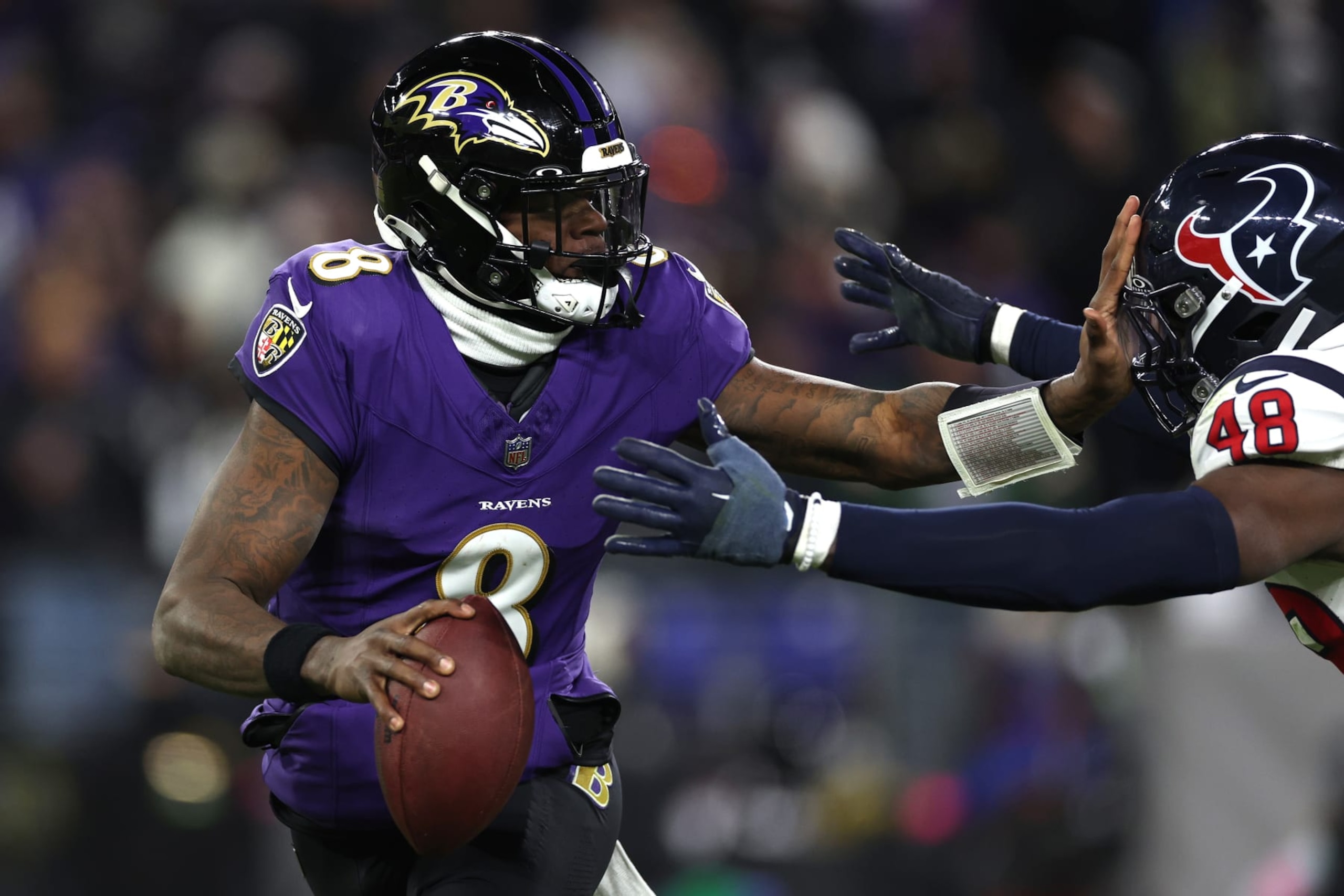 BALTIMORE, MARYLAND - JANUARY 20: Lamar Jackson #8 of the Baltimore Ravens stiff arms Christian Harris #48 of the Houston Texans during the second quarter in the AFC Divisional Playoff game at M&T Bank Stadium on January 20, 2024 in Baltimore, Maryland. (Photo by Patrick Smith/Getty Images) BALTIMORE, MARYLAND - JANUARY 20: Lamar Jackson #8 of the Baltimore Ravens stiff arms Christian Harris #48 of the Houston Texans during the second quarter in the AFC Divisional Playoff game at M&T Bank Stadium on January 20, 2024 in Baltimore, Maryland. (Photo by Patrick Smith/Getty Images)