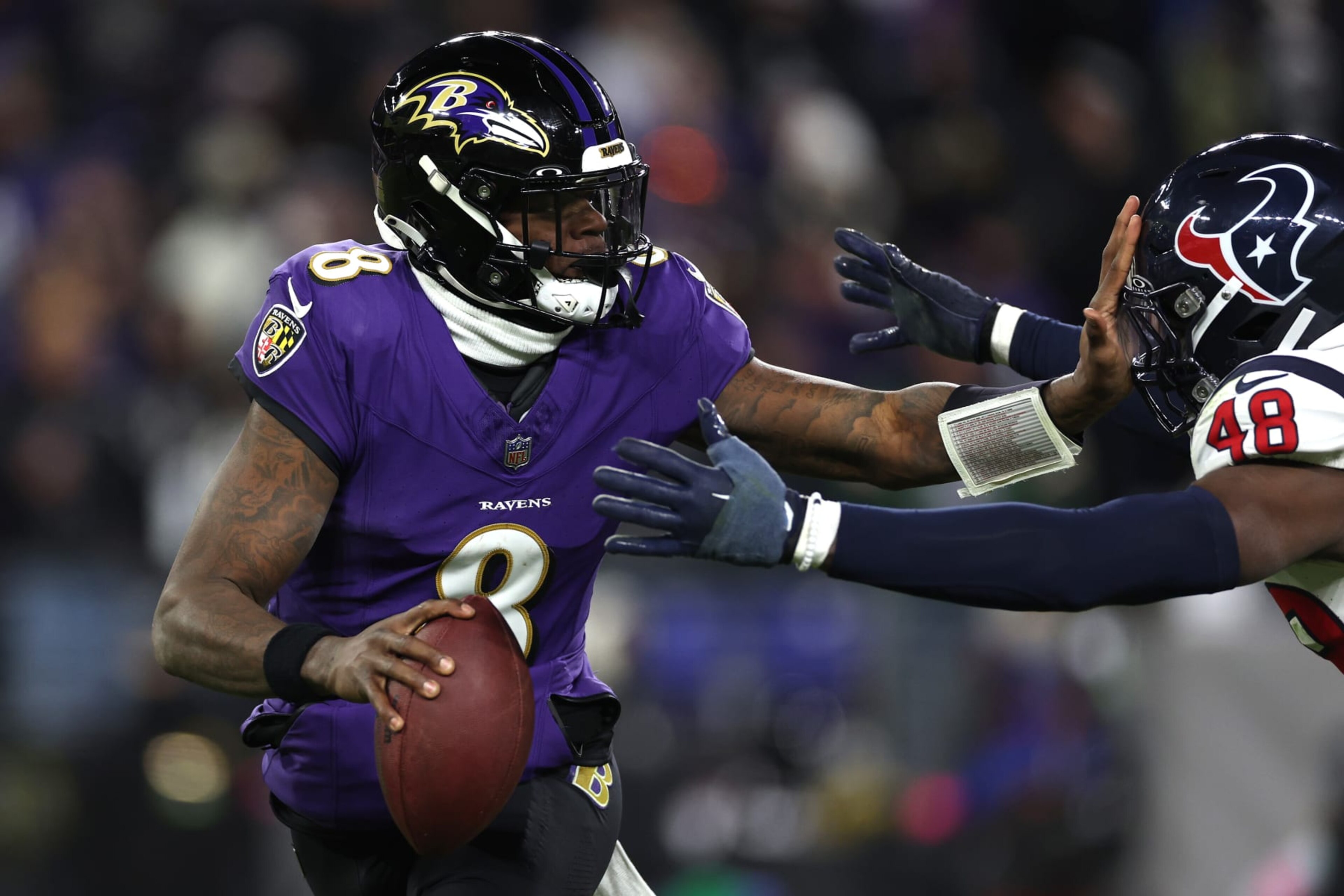 BALTIMORE, MARYLAND - JANUARY 20: Lamar Jackson #8 of the Baltimore Ravens stiff arms Christian Harris #48 of the Houston Texans during the second quarter in the AFC Divisional Playoff game at M&T Bank Stadium on January 20, 2024 in Baltimore, Maryland. (Photo by Patrick Smith/Getty Images) BALTIMORE, MARYLAND - JANUARY 20: Lamar Jackson #8 of the Baltimore Ravens stiff arms Christian Harris #48 of the Houston Texans during the second quarter in the AFC Divisional Playoff game at M&T Bank Stadium on January 20, 2024 in Baltimore, Maryland. (Photo by Patrick Smith/Getty Images)
