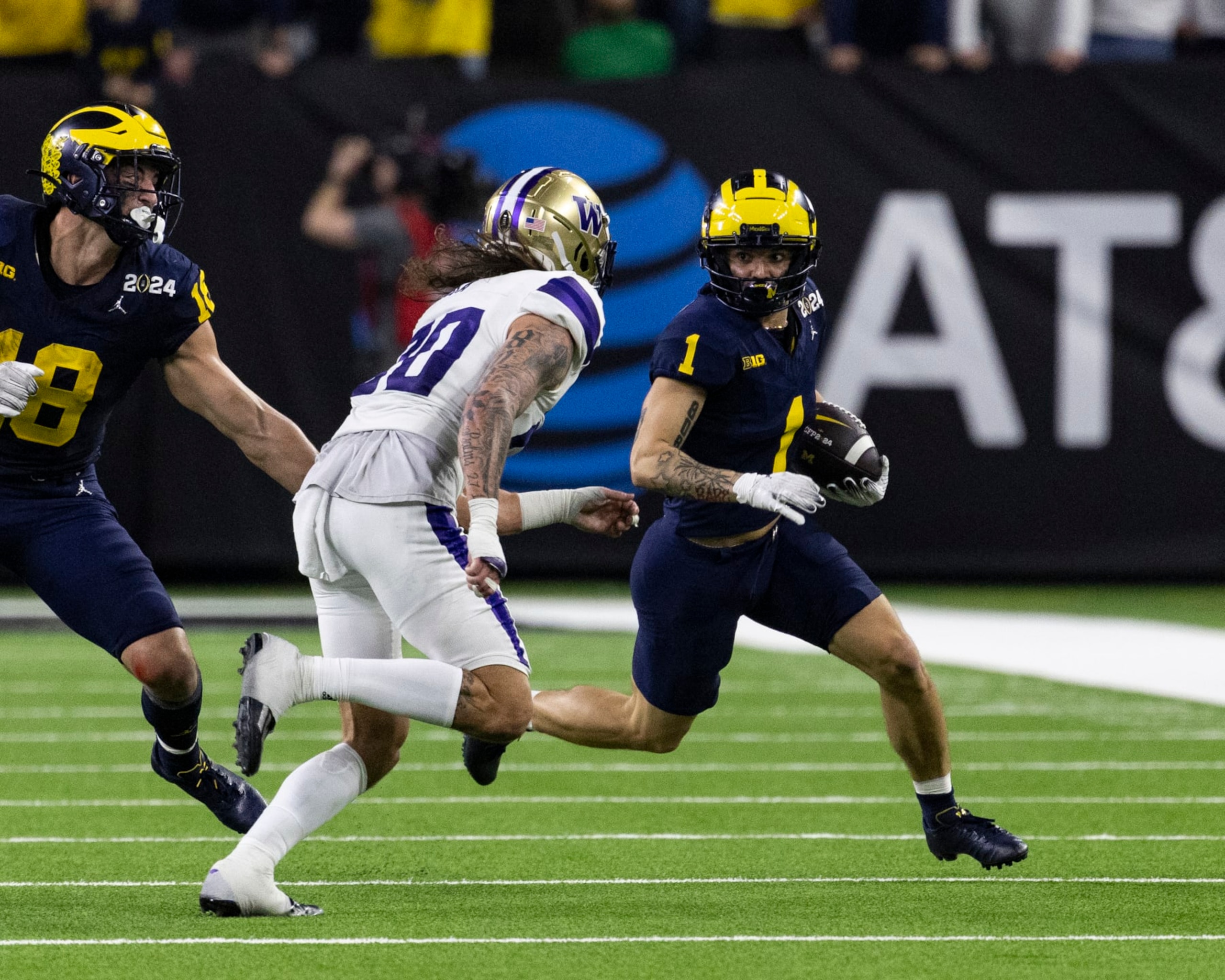 HOUSTON, TX - JANUARY 08: Roman Wilson #1 of the Michigan Wolverines tries to get around Asa Turner #20 of the Washington Huskies between University of Washington and University of Michigan at NRG Stadium on January 8, 2024 in Houston, Texas. (Photo by Steve Limentani/ISI Photos/Getty Images)