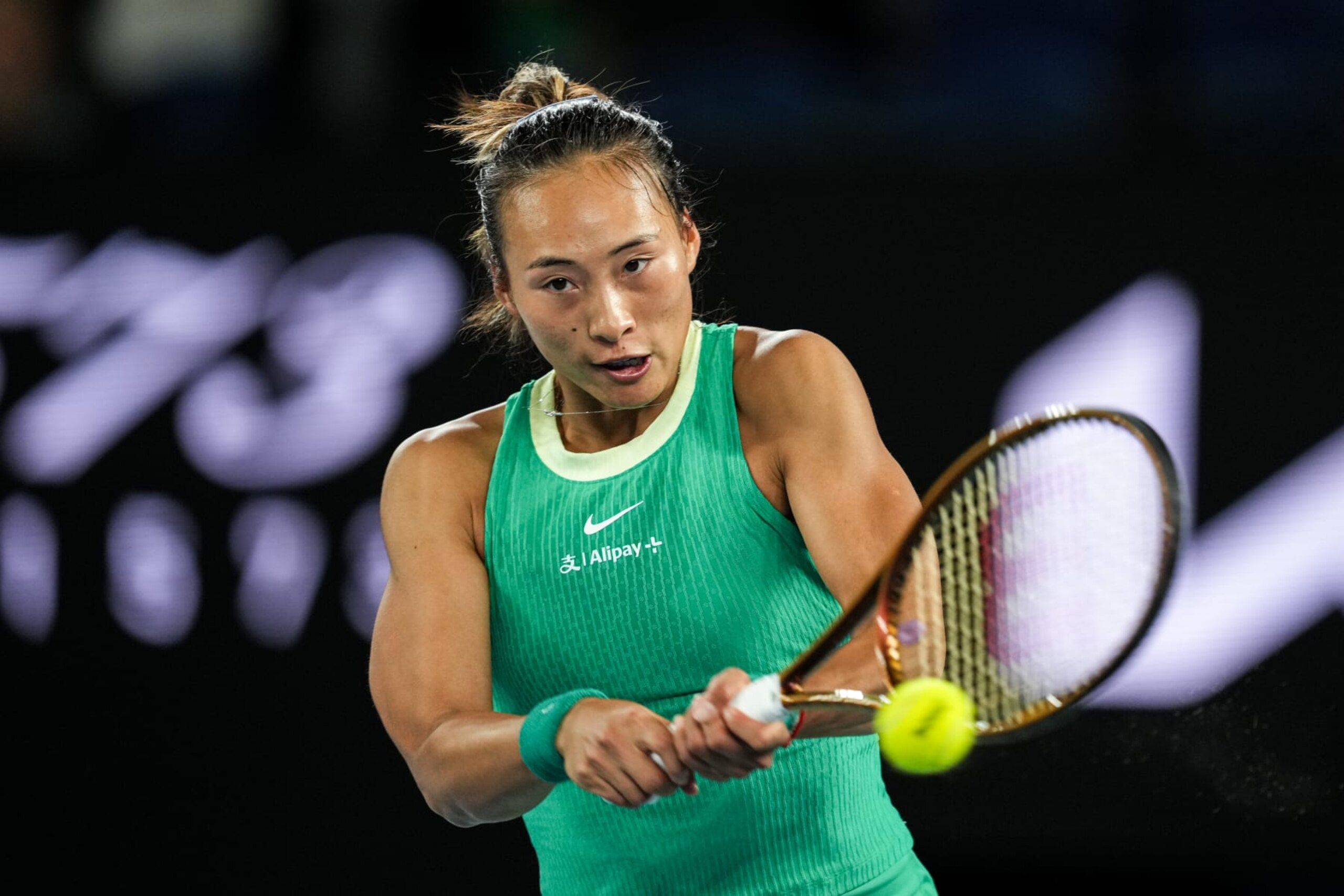 MELBOURNE, AUSTRALIA - JANUARY 22: Qinwen Zheng of China plays a backhand in the Women's Singles Fourth Round match against Oceane Dodin of France during day nine of the 2024 Australian Open at Melbourne Park on January 22, 2024 in Melbourne, Australia. (Photo by Shi Tang/Getty Images)