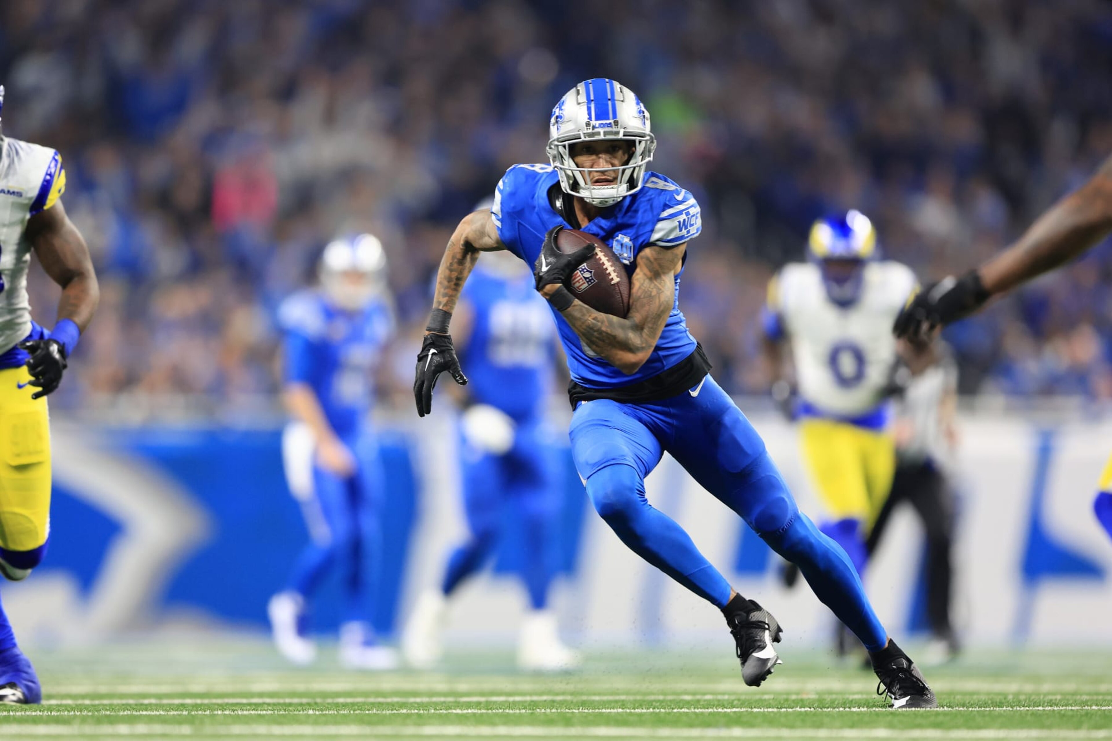 DETROIT, MICHIGAN - JANUARY 14: Josh Reynolds #8 of the Detroit Lions runs with the ball during the first half against the Los Angeles Rams in the NFC Wild Card Playoffs at Ford Field on January 14, 2024 in Detroit, Michigan. (Photo by Rey Del Rio/Getty Images) DETROIT, MICHIGAN - JANUARY 14: Josh Reynolds #8 of the Detroit Lions runs with the ball during the first half against the Los Angeles Rams in the NFC Wild Card Playoffs at Ford Field on January 14, 2024 in Detroit, Michigan. (Photo by Rey Del Rio/Getty Images)