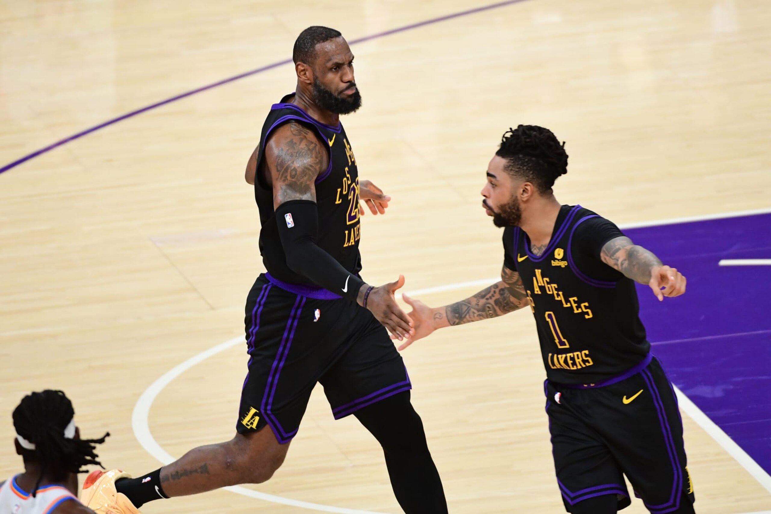 LOS ANGELES, CA - JANUARY 15: LeBron James  #23 and D'Angelo Russell #1 of the Los Angeles Lakers high five during the game against the Oklahoma City Thunder on January 15, 2024 at Crypto.Com Arena in Los Angeles, California. NOTE TO USER: User expressly acknowledges and agrees that, by downloading and/or using this Photograph, user is consenting to the terms and conditions of the Getty Images License Agreement. Mandatory Copyright Notice: Copyright 2024 NBAE (Photo by Adam Pantozzi/NBAE via Getty Images)