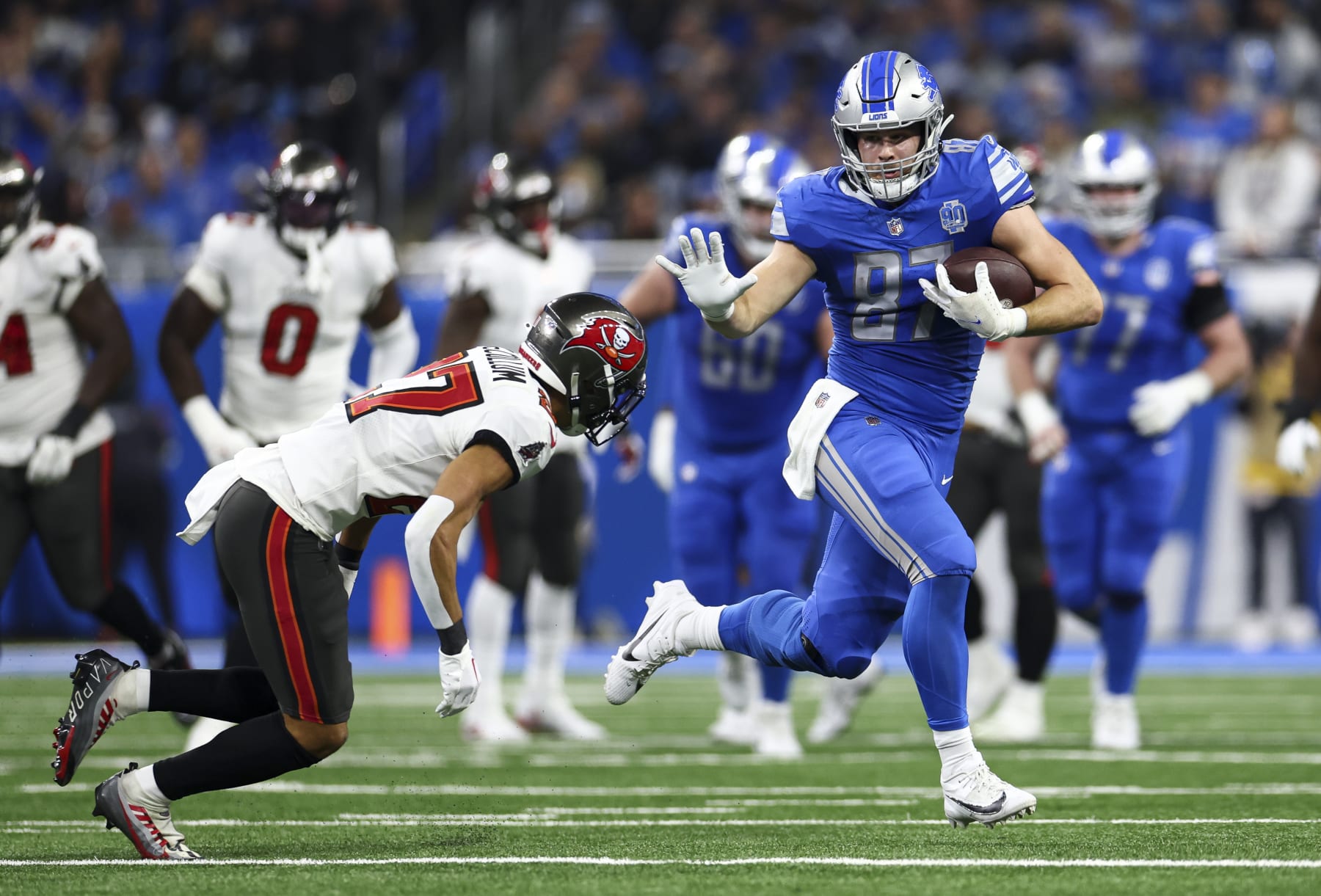 DETROIT, MI - JANUARY 21: Sam LaPorta #87 of the Detroit Lions stiff arms Zyon McCollum #27 of the Tampa Bay Buccaneers during the second quarter of an NFL divisional round playoff football game at Ford Field on January 21, 2024 in Detroit, Michigan. (Photo by Kevin Sabitus/Getty Images)