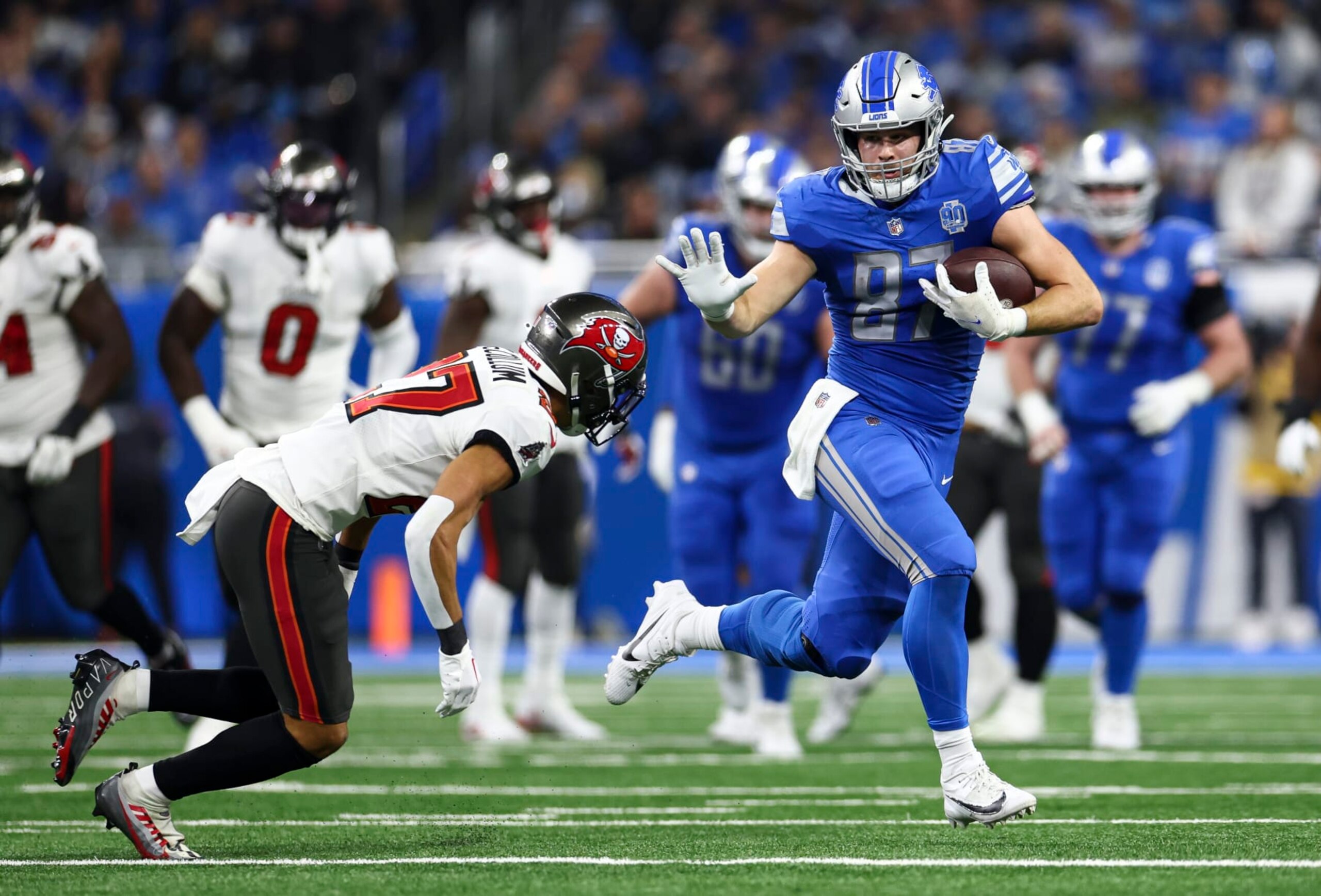 DETROIT, MI - JANUARY 21: Sam LaPorta #87 of the Detroit Lions stiff arms Zyon McCollum #27 of the Tampa Bay Buccaneers during the second quarter of an NFL divisional round playoff football game at Ford Field on January 21, 2024 in Detroit, Michigan. (Photo by Kevin Sabitus/Getty Images) DETROIT, MI - JANUARY 21: Sam LaPorta #87 of the Detroit Lions stiff arms Zyon McCollum #27 of the Tampa Bay Buccaneers during the second quarter of an NFL divisional round playoff football game at Ford Field on January 21, 2024 in Detroit, Michigan. (Photo by Kevin Sabitus/Getty Images)