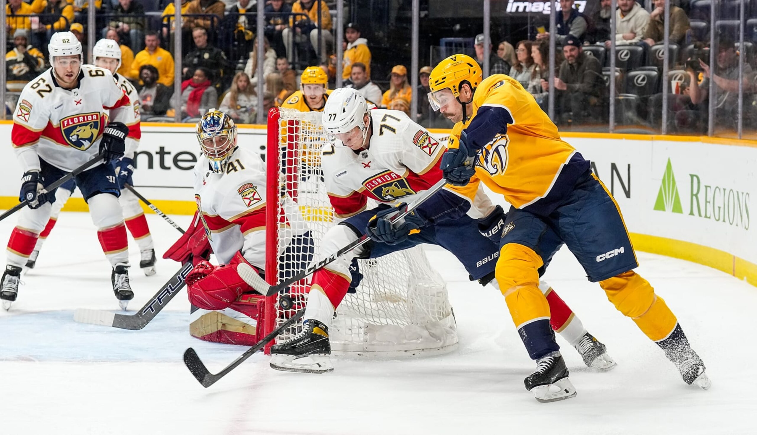NASHVILLE, TENNESSEE - JANUARY 22: Filip Forsberg #9 of the Nashville Predators tries a wrap around shot against Niko Mikkola #77 and Anthony Stolarz #41 of the Florida Panthers during an NHL game at Bridgestone Arena on January 22, 2024 in Nashville, Tennessee. (Photo by John Russell/NHLI via Getty Images)